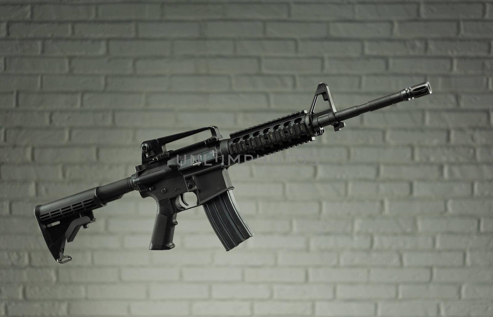 the American army rifle M4A1 against a brick wall