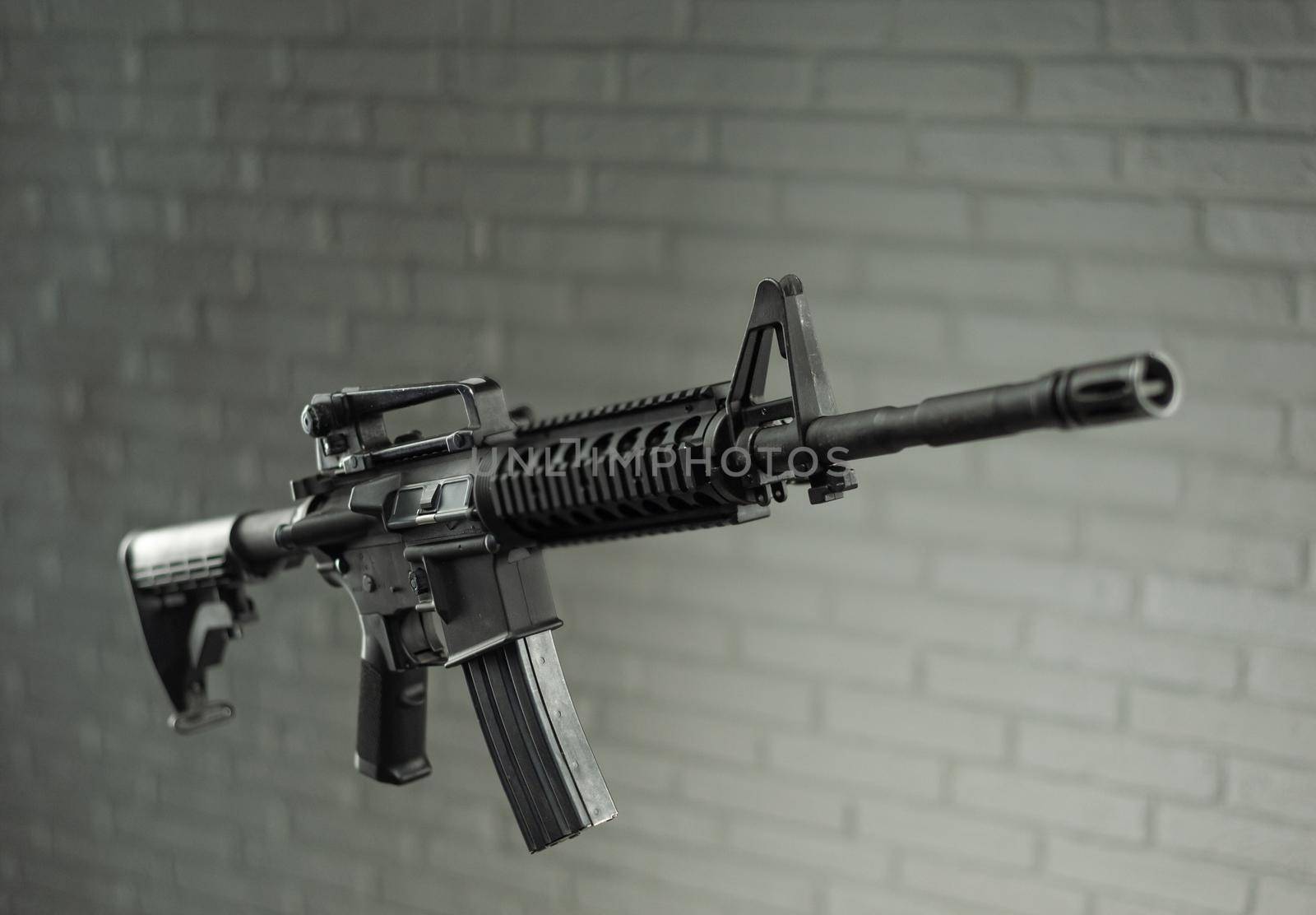 the American army rifle M4A1 against a brick wall