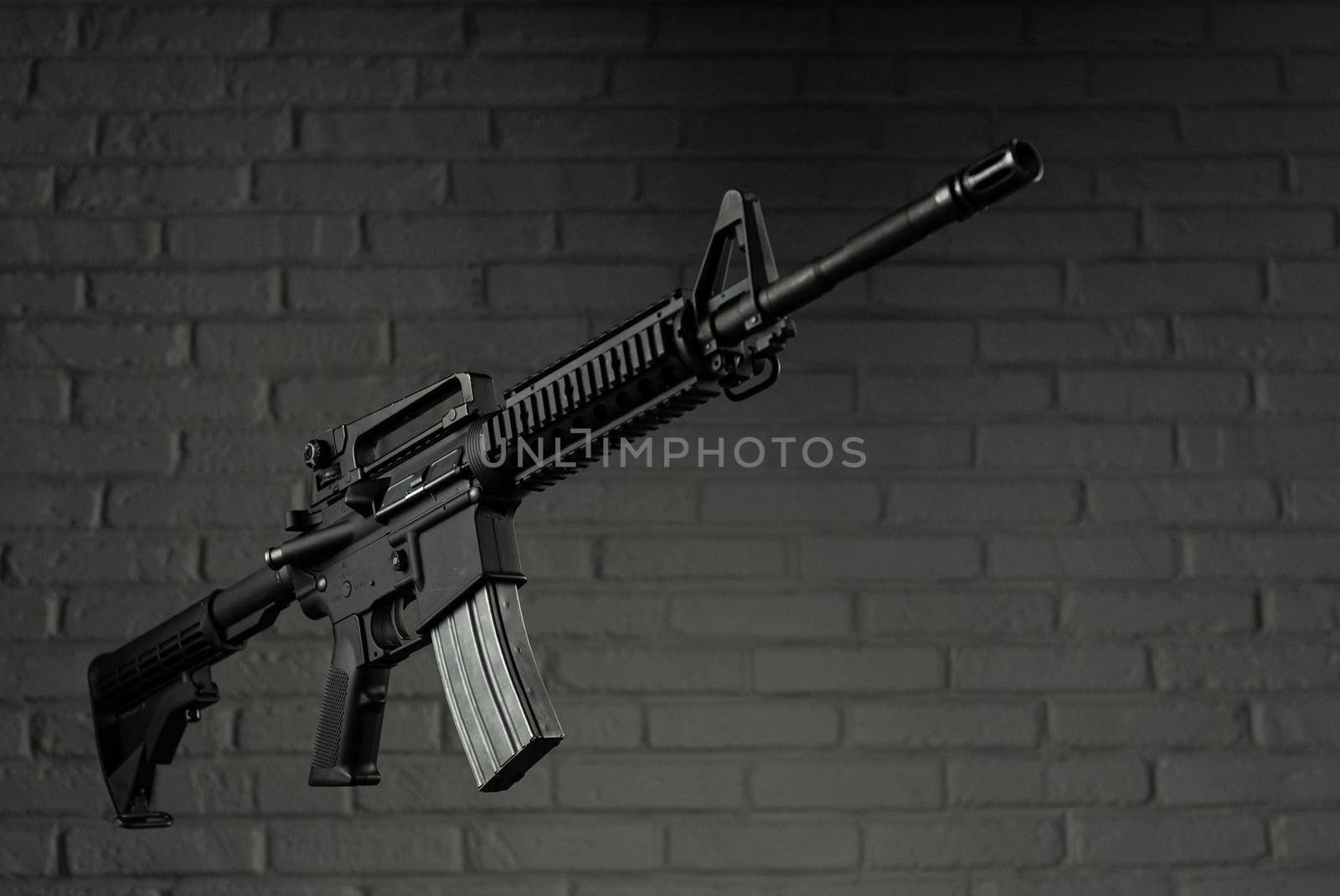 American army rifle M4A1 against a brick wall by Rotozey