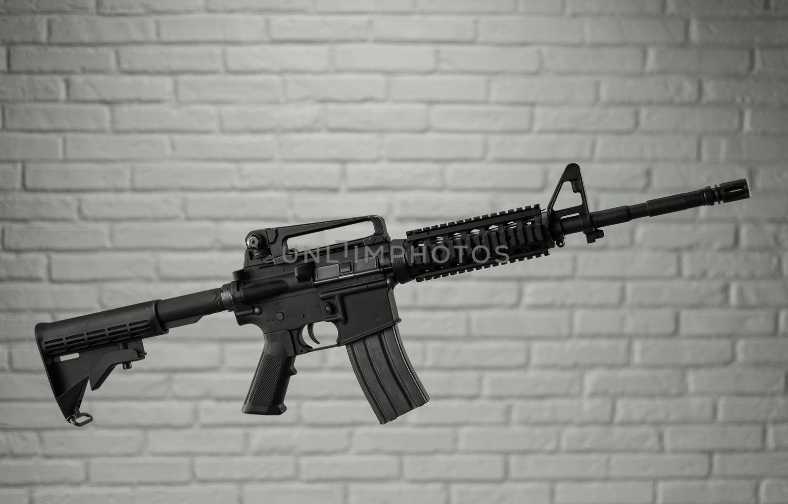 American army rifle M4A1 against a brick wall by Rotozey