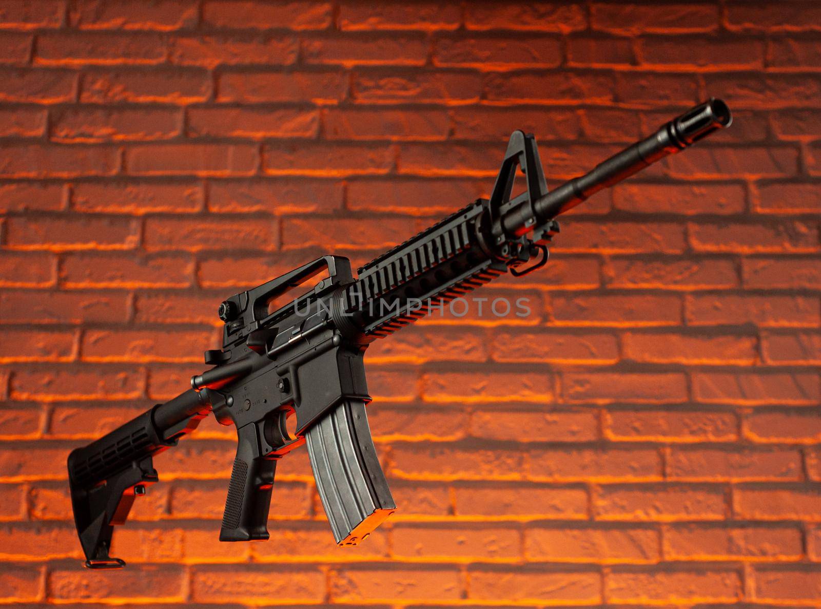 the American army rifle M4A1 against a brick wall