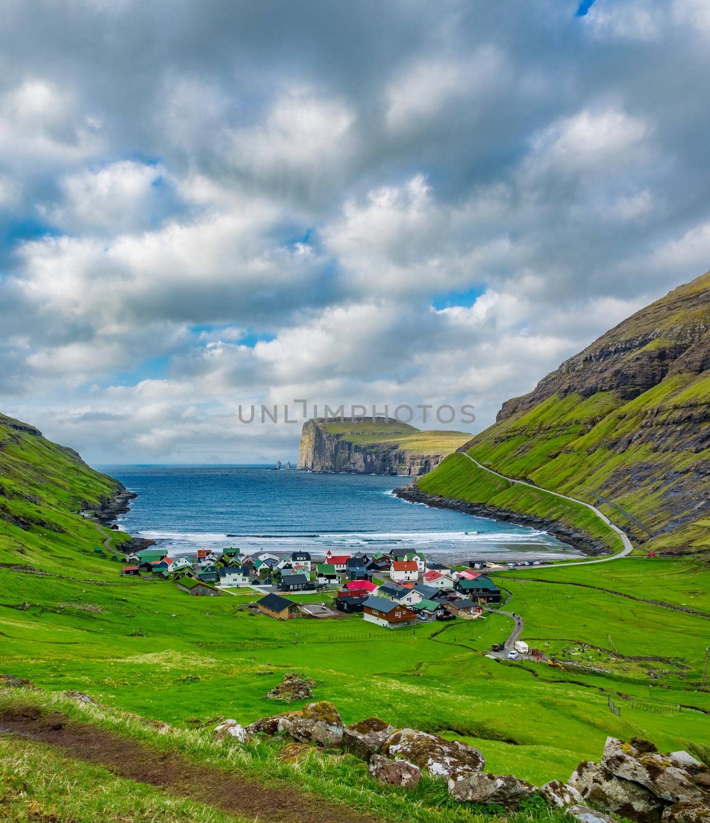 Risin and Kellingin, The Giant and the Wich far in the distance with Tjornuvik village in the foreground under the clouds