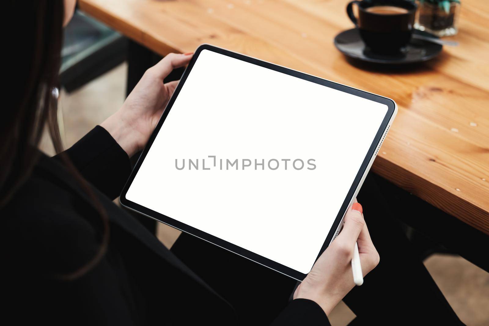 business woman holding digital tablet and stylus pencil at cafe.