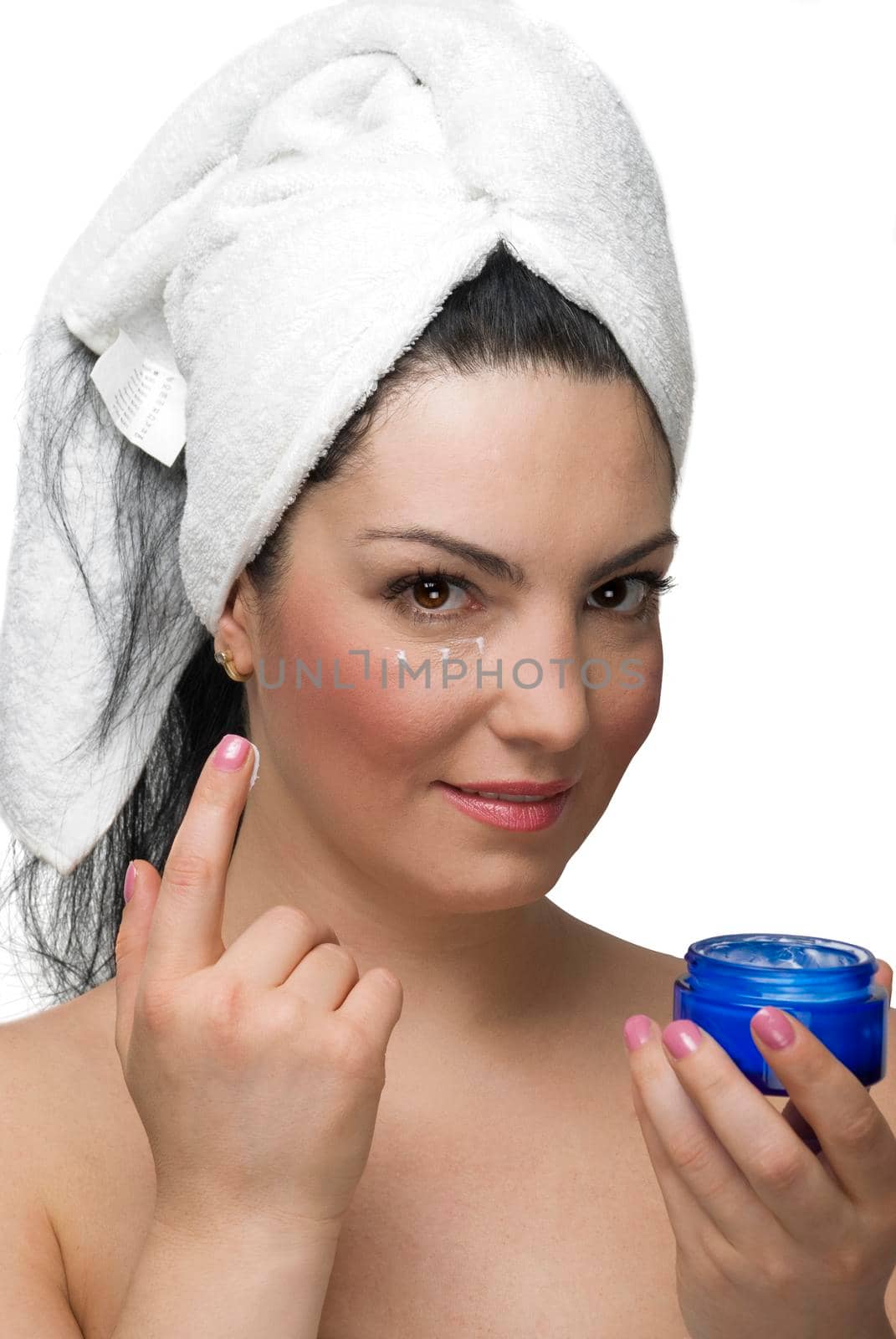 Beautiful woman in white bath towel using cream for eyes skin isolated on white background