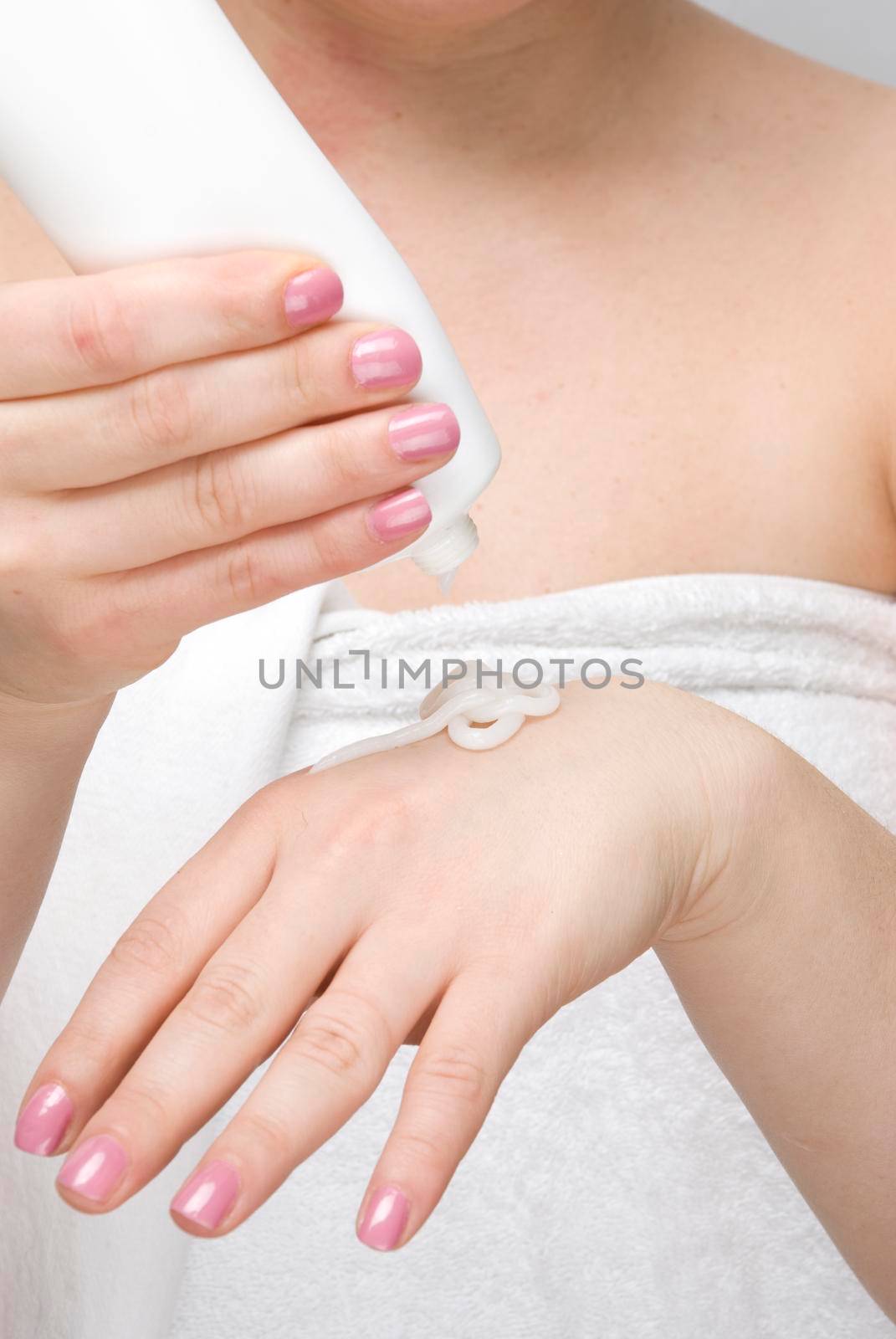Close up of woman body using cream for hands and nails