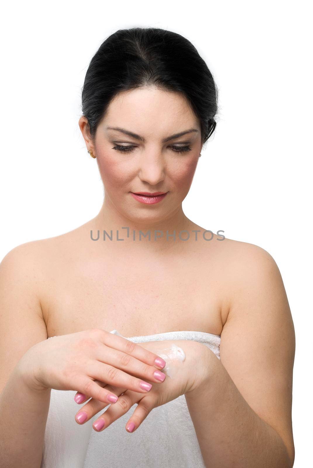 Young woman in white bath towel  massaging her hands with cream in front of image isolated on white background