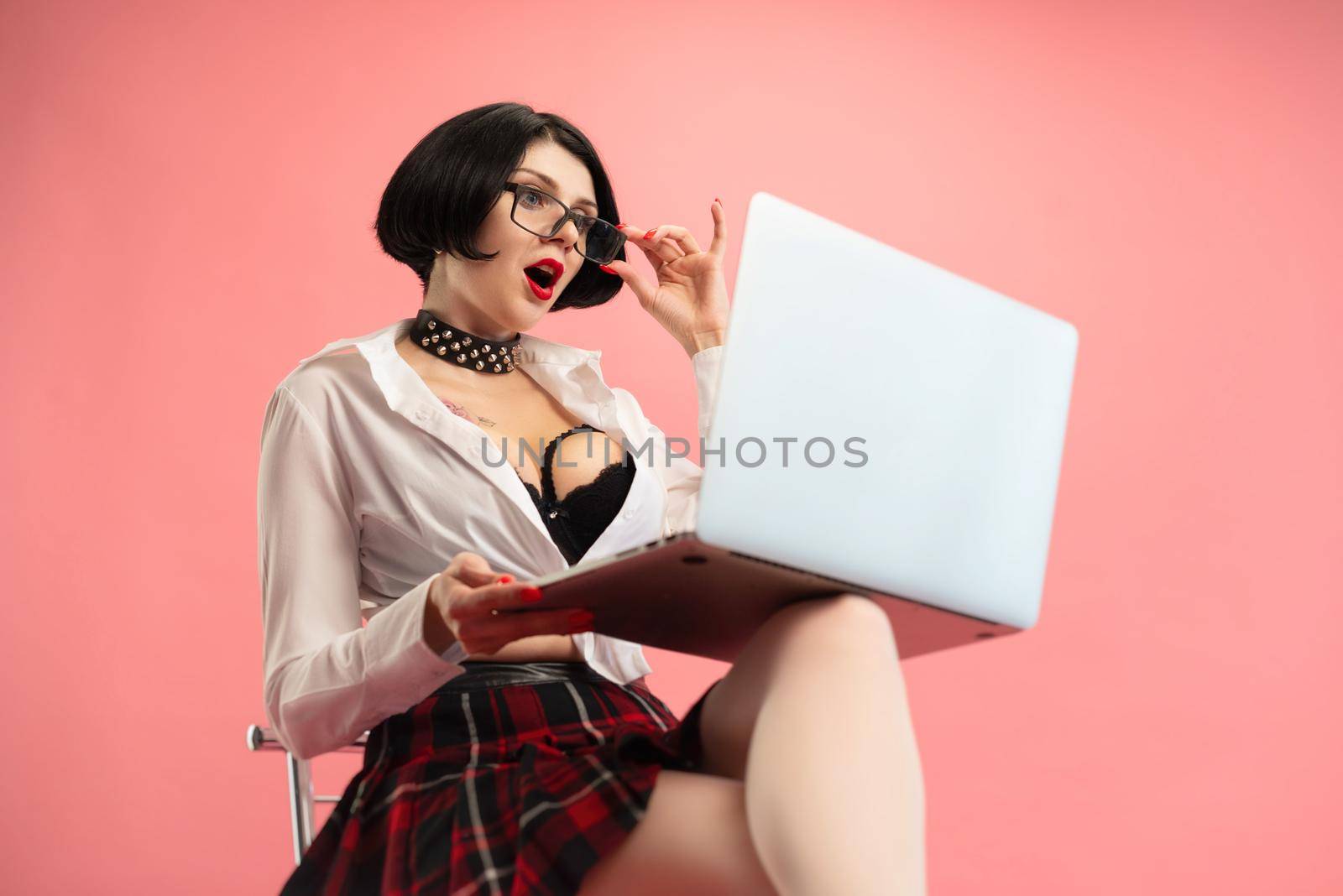 seductive woman with glasses and a laptop reacts sexually with emotions to online flirting