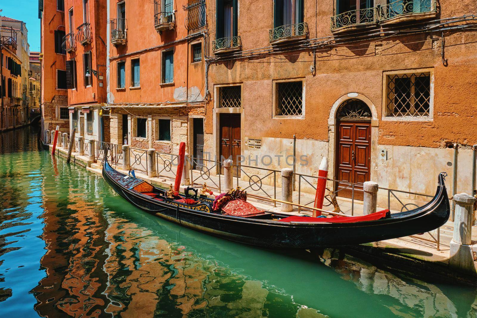 Narrow canal with gondola in Venice, Italy by dimol