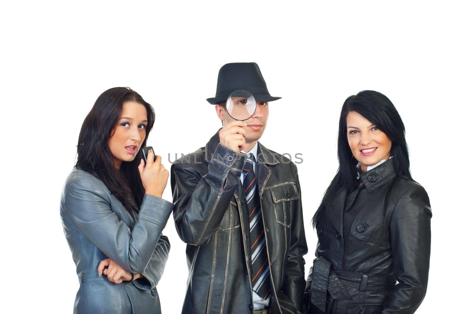 Detective man with magnifying glass in the middle of two beautiful assistants women isolated on white background