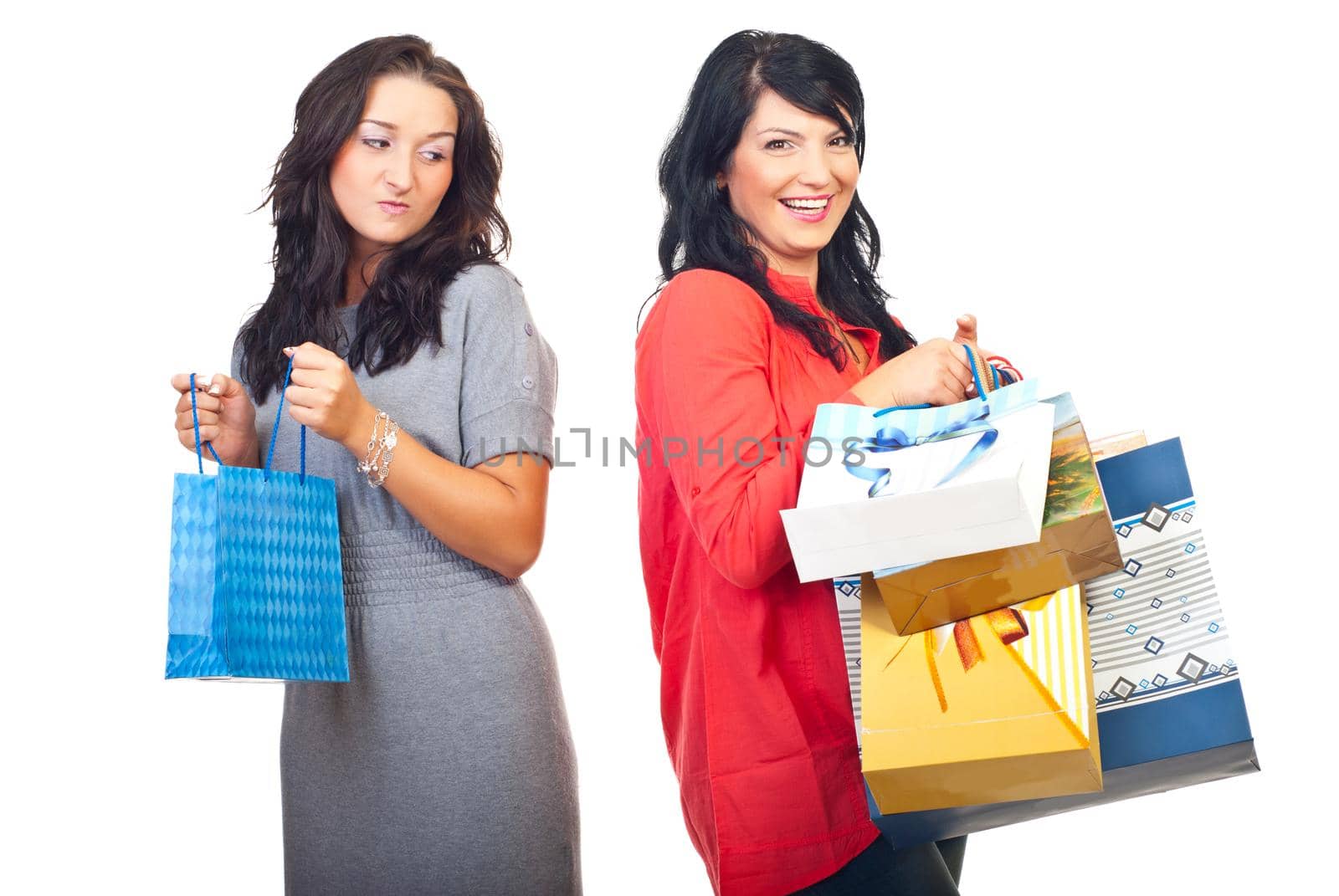 Envious woman on her friend with many shopping bags isolated on white background