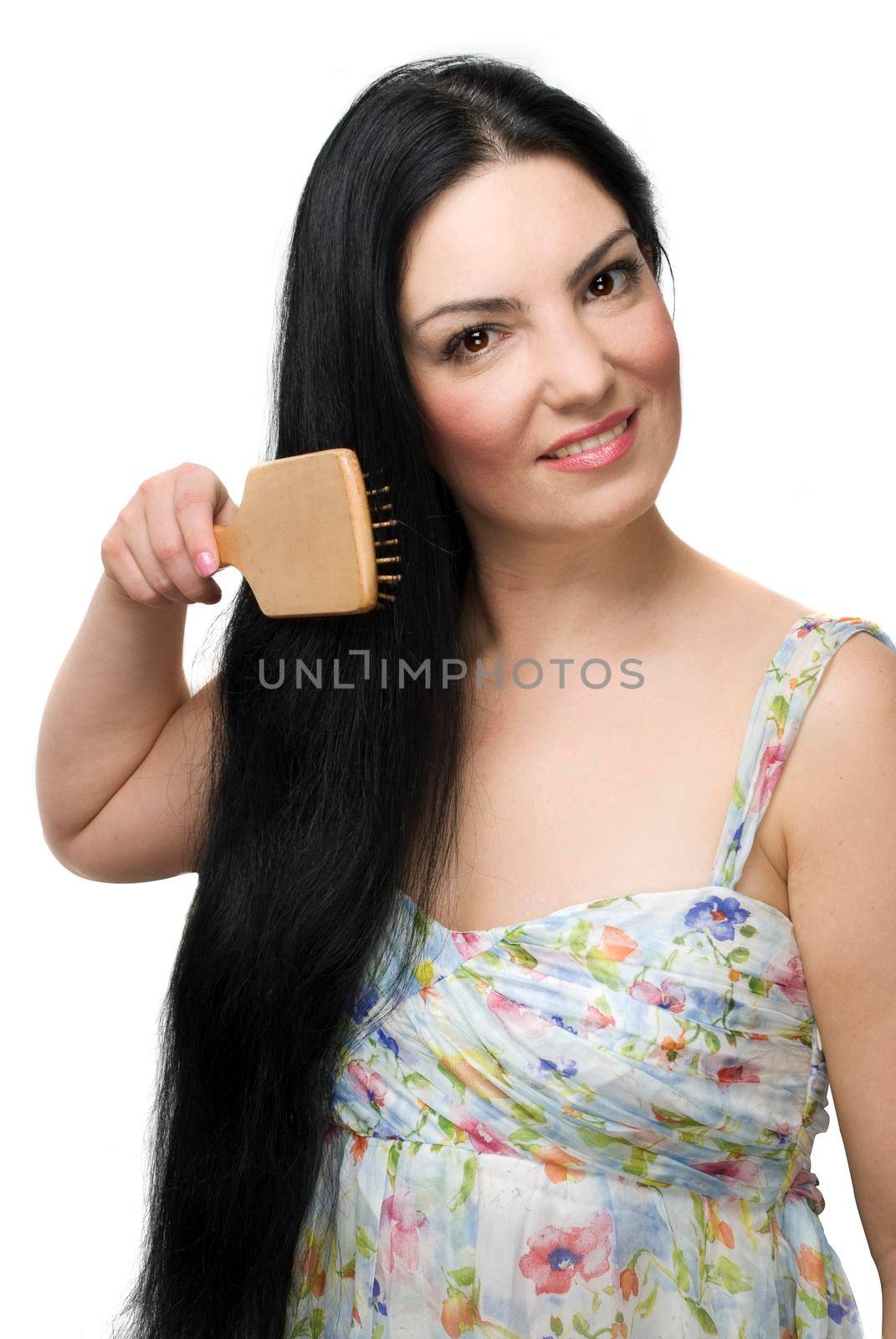 Beautiful woman brushing her long black hair and smiling isolated on white background