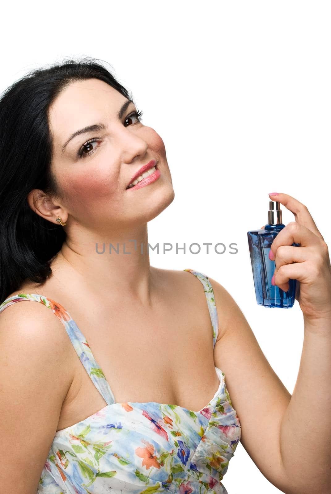 Beautiful woman smiling and holding a blue perfume in her hand isolated on white background