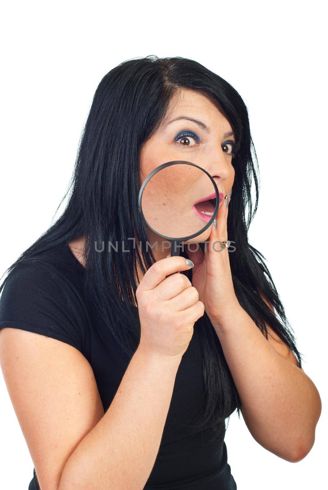 Scared woman with acne holding a magnyfing glass and checchink her face in the mirror isolated on white backgroun