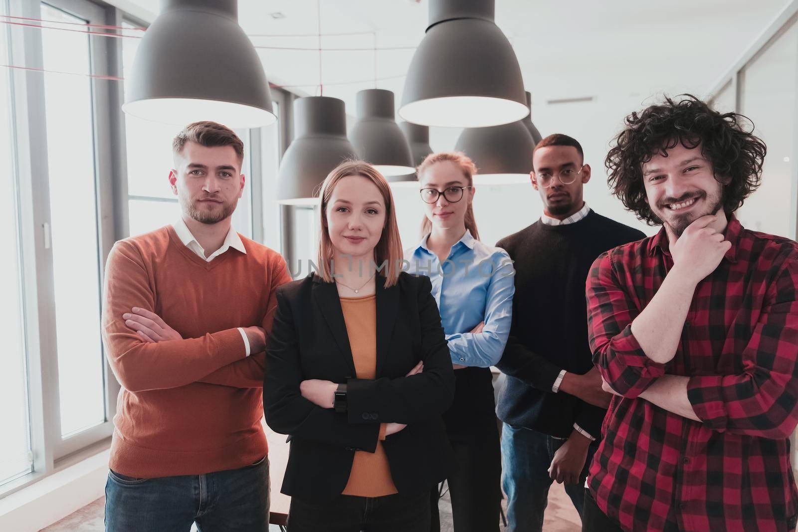 Portrait of a successful creative business team looking at camera and smiling. Diverse business people standing together at startup. Selective focus. High-quality photo