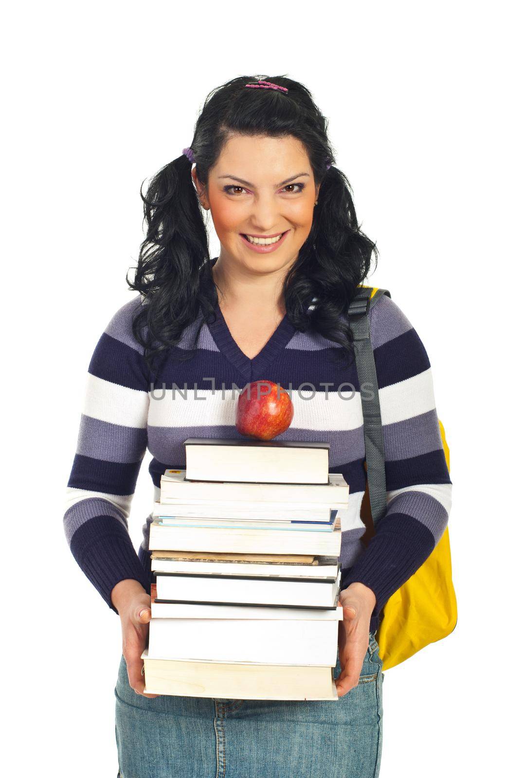 Happy student woman holding pile of books and an apple and smiling isolated on white background