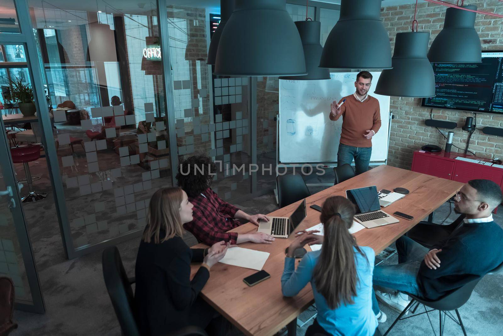 Leader give a business presentation at an office conference meeting, businessman coach mentor explains graph chart on board corporate group workshop training in boardroom. Selective focus by dotshock