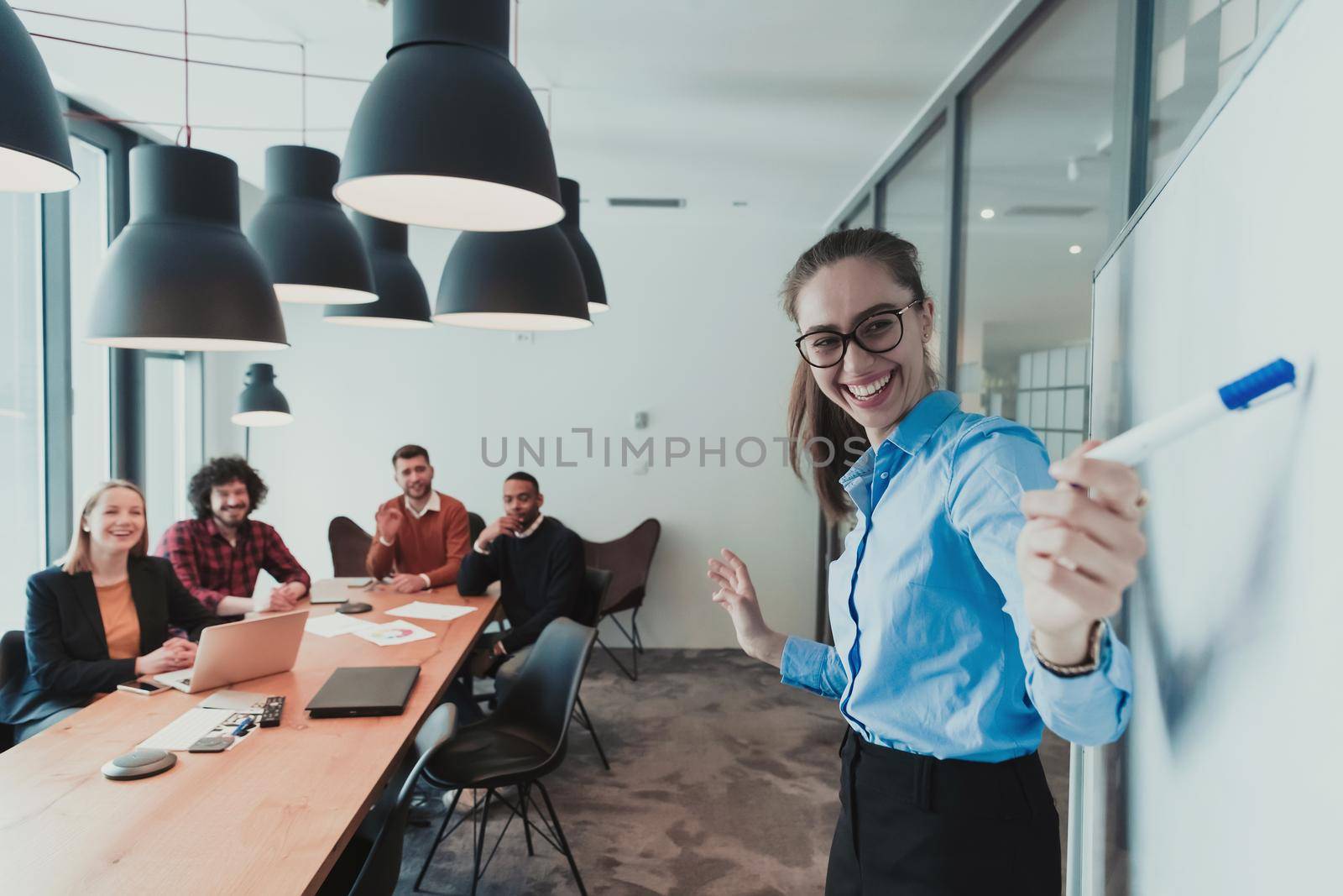 Professional woman leader presenter gives a business presentation at an office conference meeting, businesswoman coach mentor explains graph chart on flipchart corporate group workshop training in boardroom. Selective focus . High quality photo