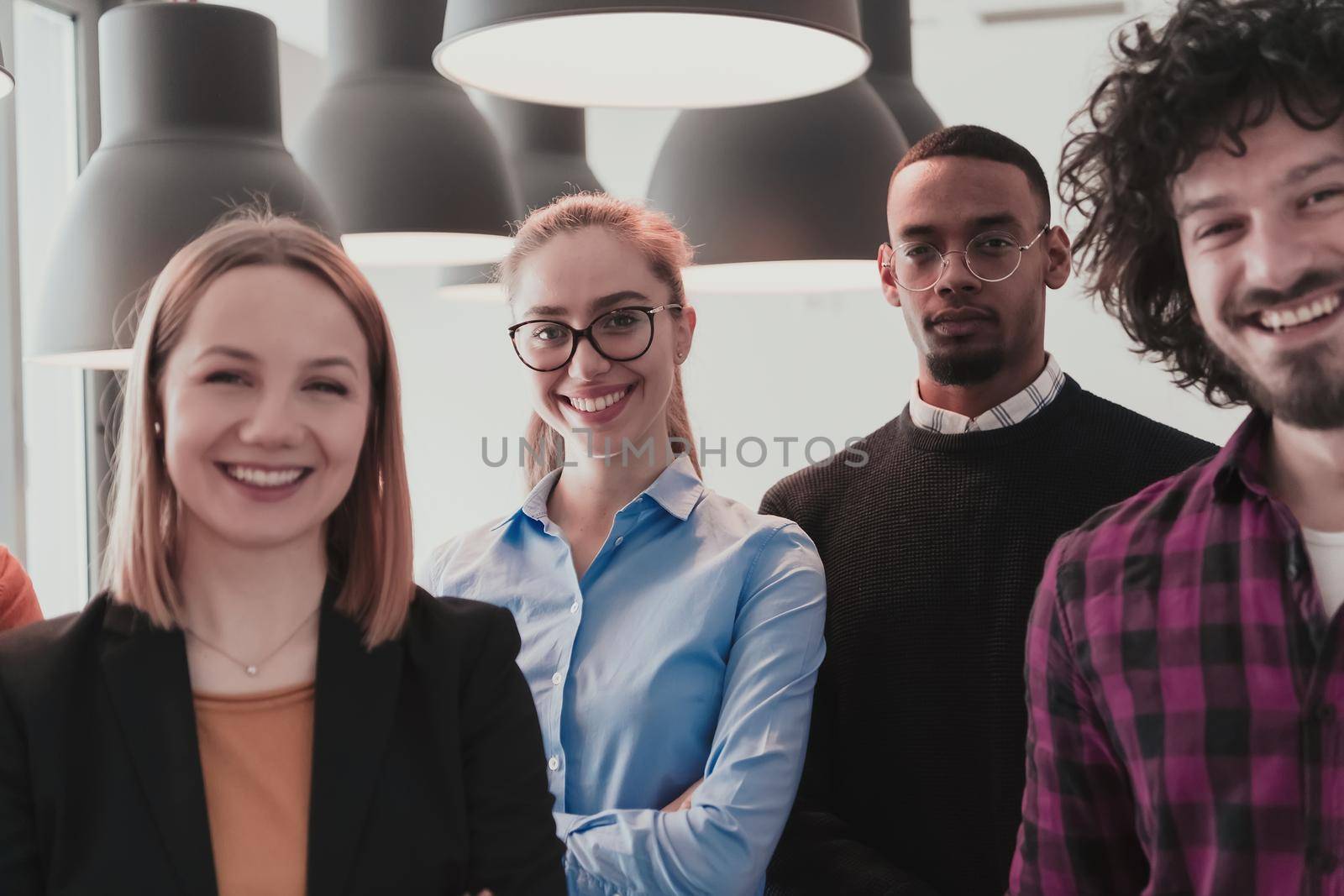 Portrait of successful creative business team looking at camera and smiling. Diverse business people standing together at startup. Selective focus by dotshock