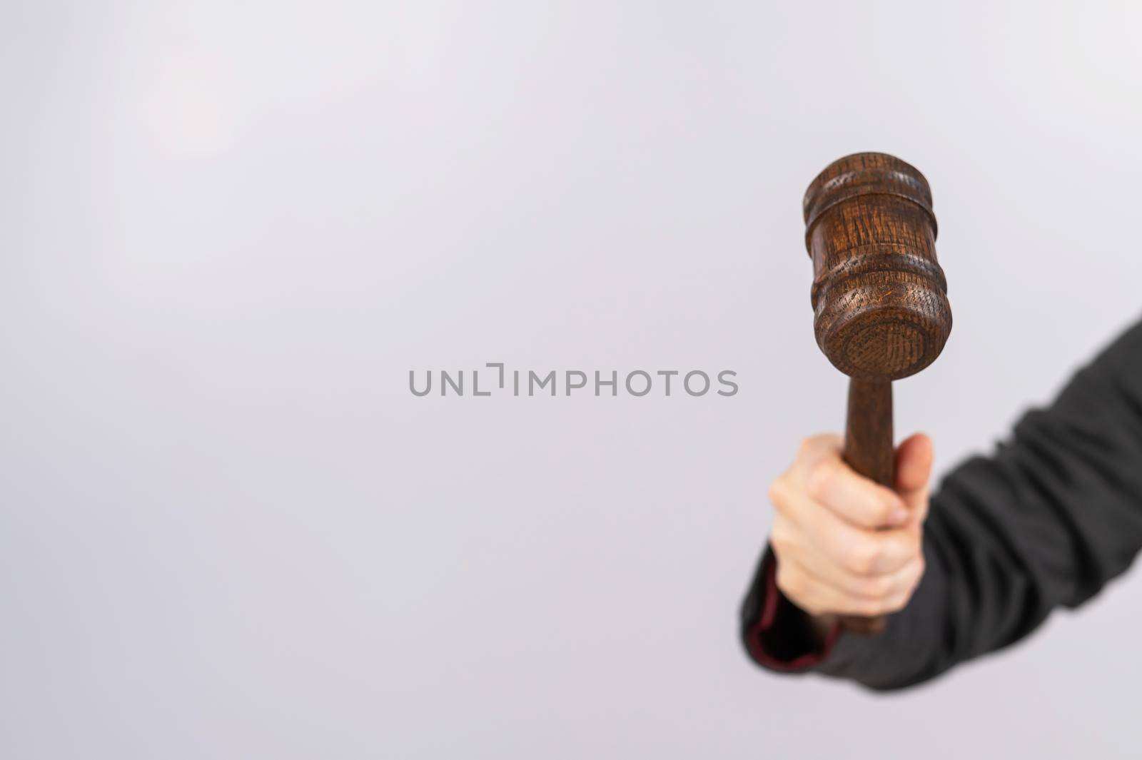 Woman holding judge's gavel on white background