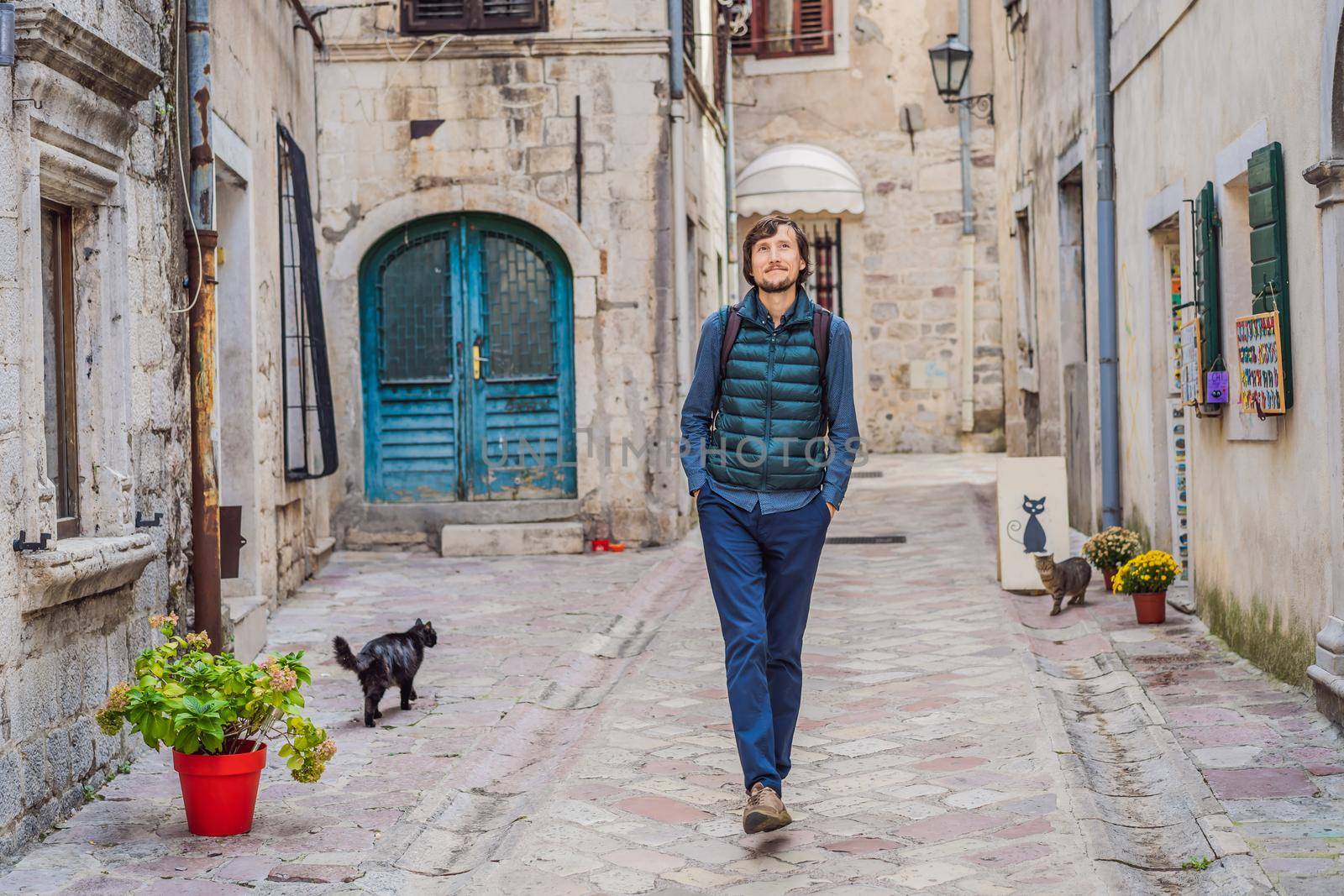 Man tourist enjoying Colorful street in Old town of Kotor on a sunny day, Montenegro. Travel to Montenegro concept.