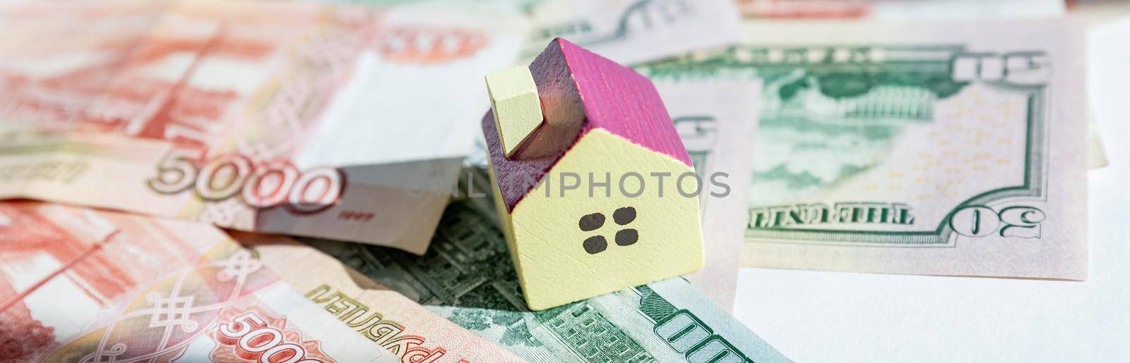 Home keys and a small house on currencies euro background. The concept of renting or selling house or flat, mortgage