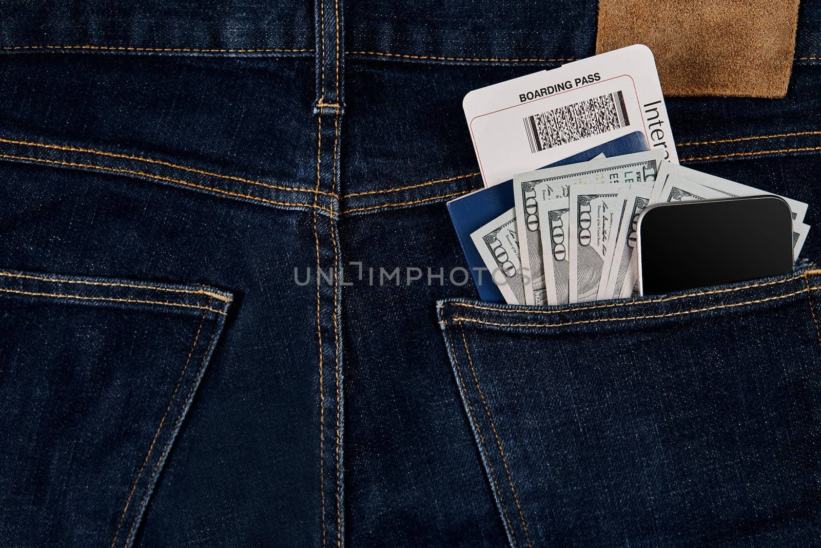 Dollars, smart, passport and plane ticket in your pocket jeans. Top view. Copy space. Still life. Flat lay
