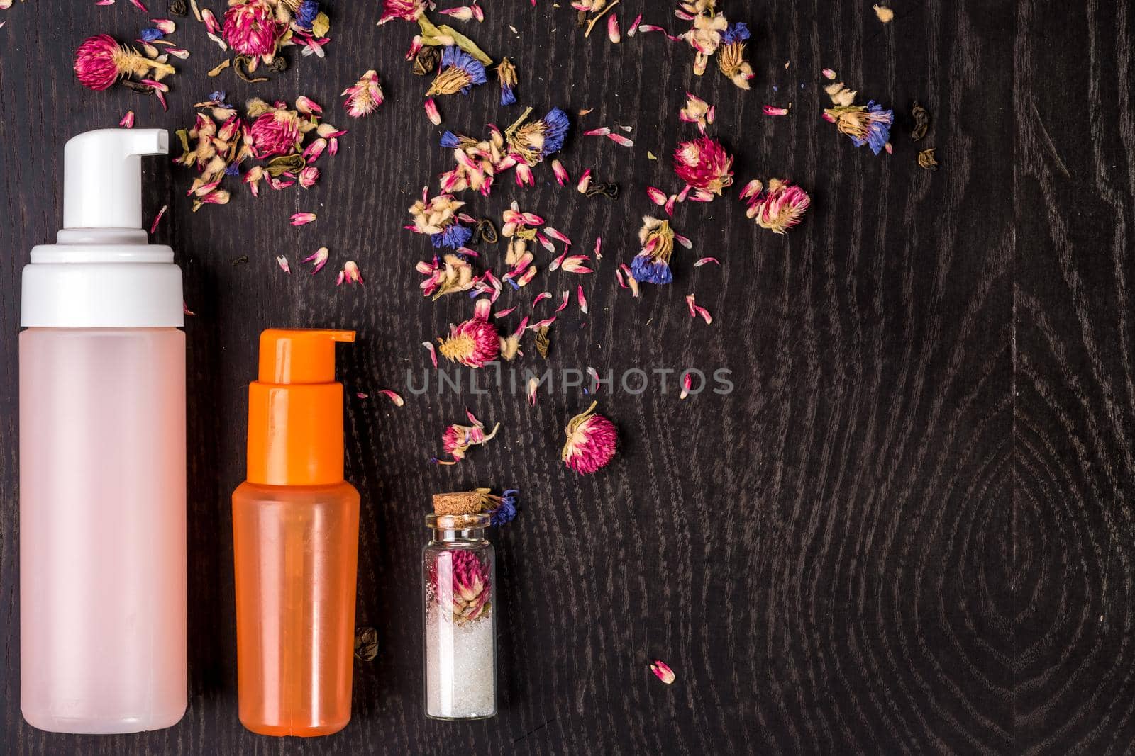 Petals, dry flowers and women's accessories on black background. Flat lay, Top view. Copy space
