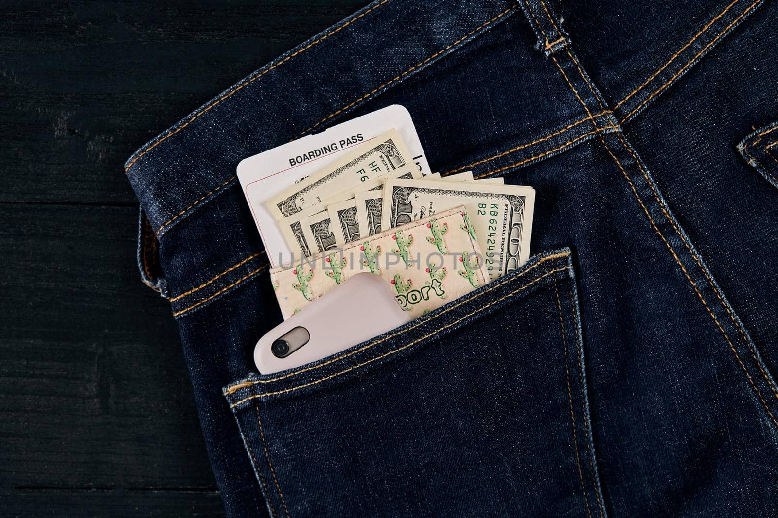 Dollars, smart and plane ticket in your pocket jeans. Top view. Copy space. Still life. Flat lay