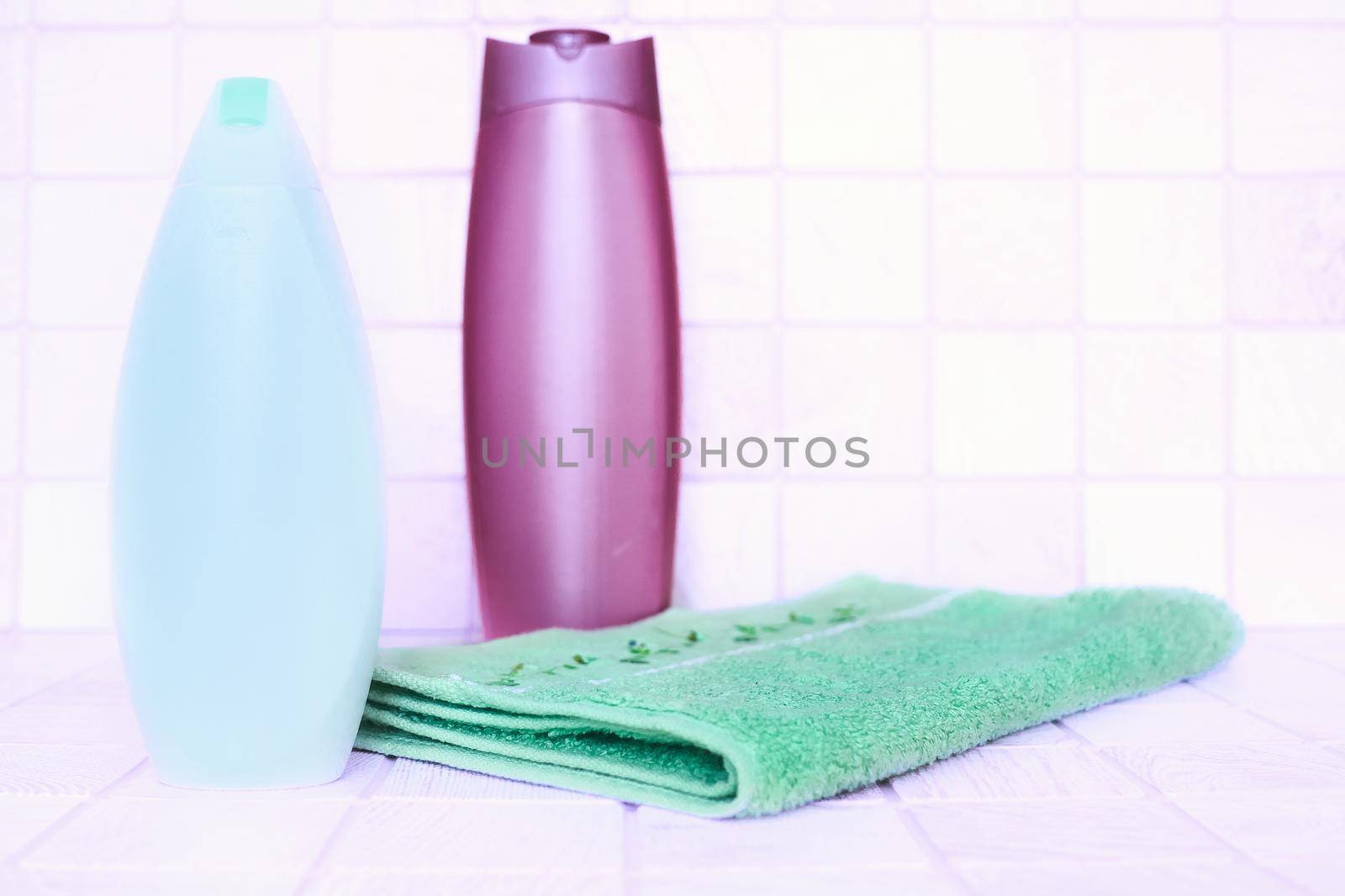 two plastic bottles for detergents and shampoos, a towel on a pink background by jovani68