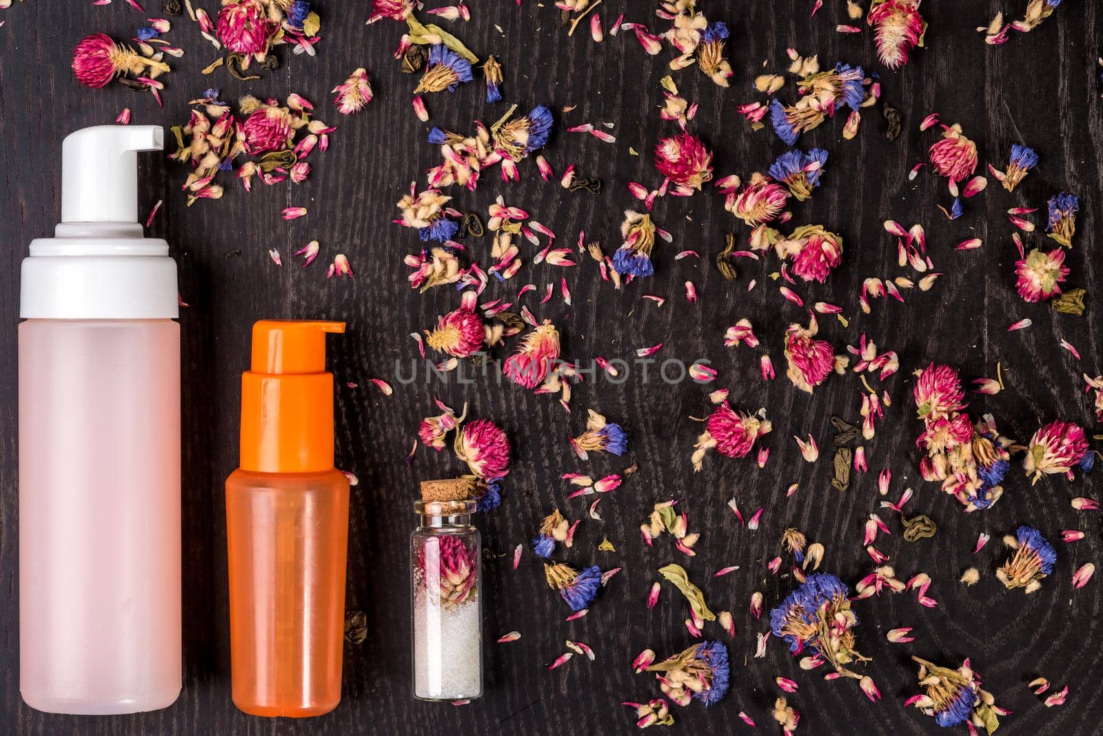 Petals, dry flowers and women's accessories on black background. Flat lay, Top view. Copy space