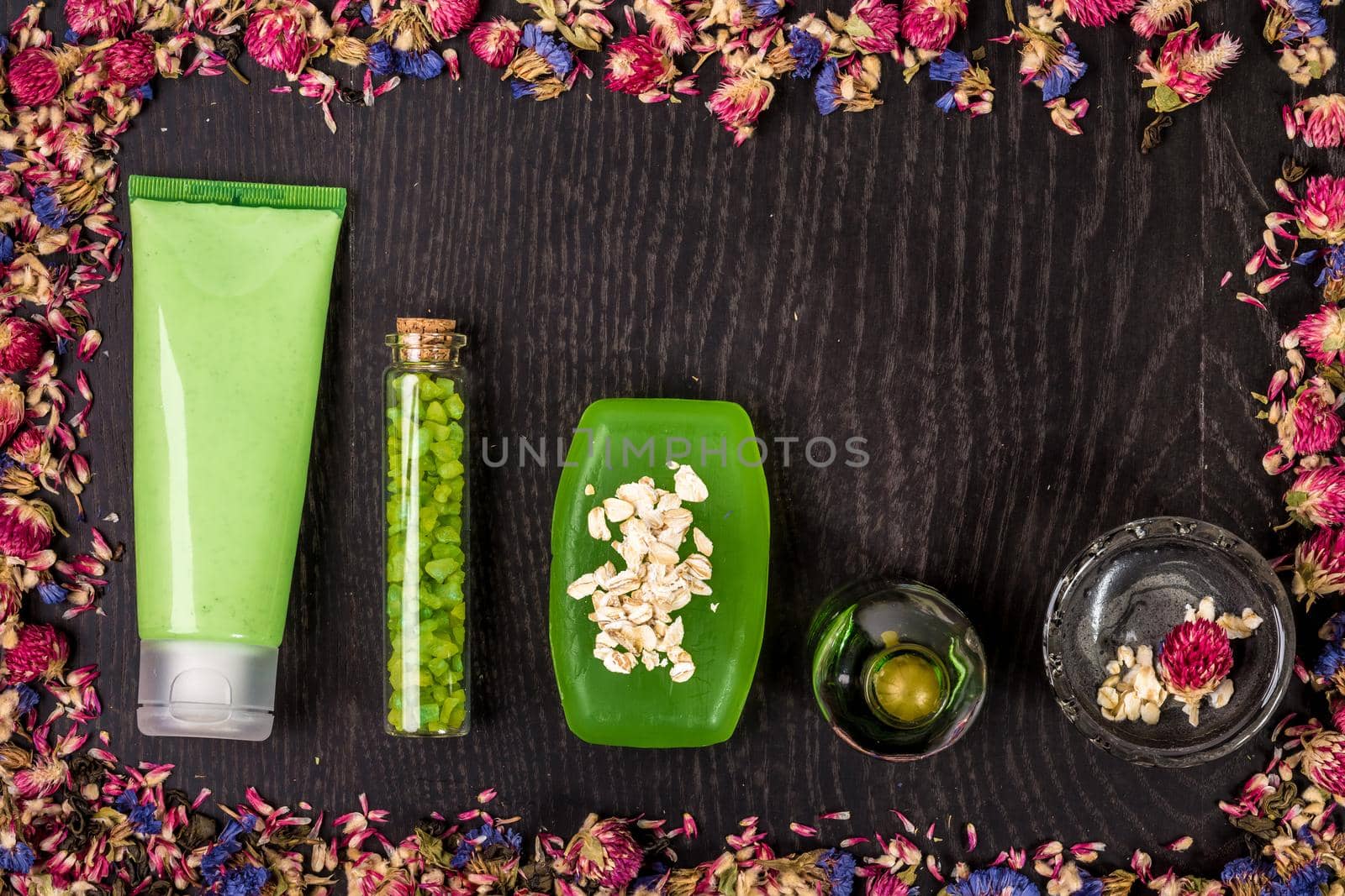 Cosmetic hygienic products with flowers on wooden background. Still life. Top view. Copy space