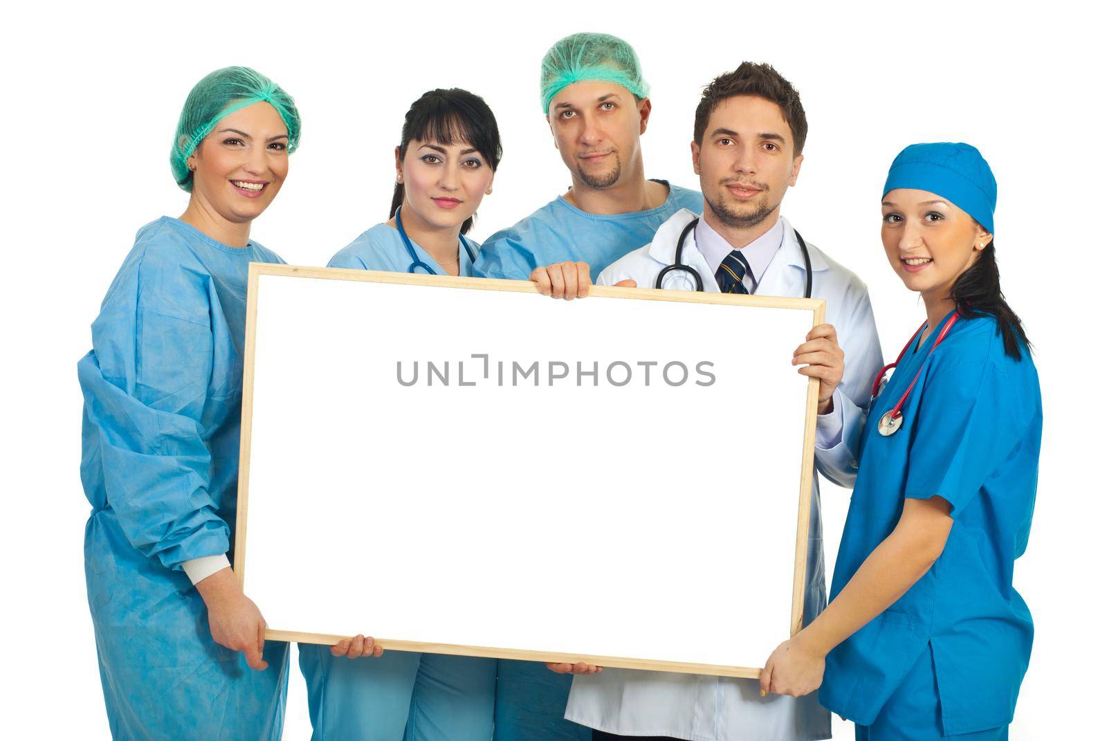 Cheerful team of five doctors holding a blank banner isolated on white background