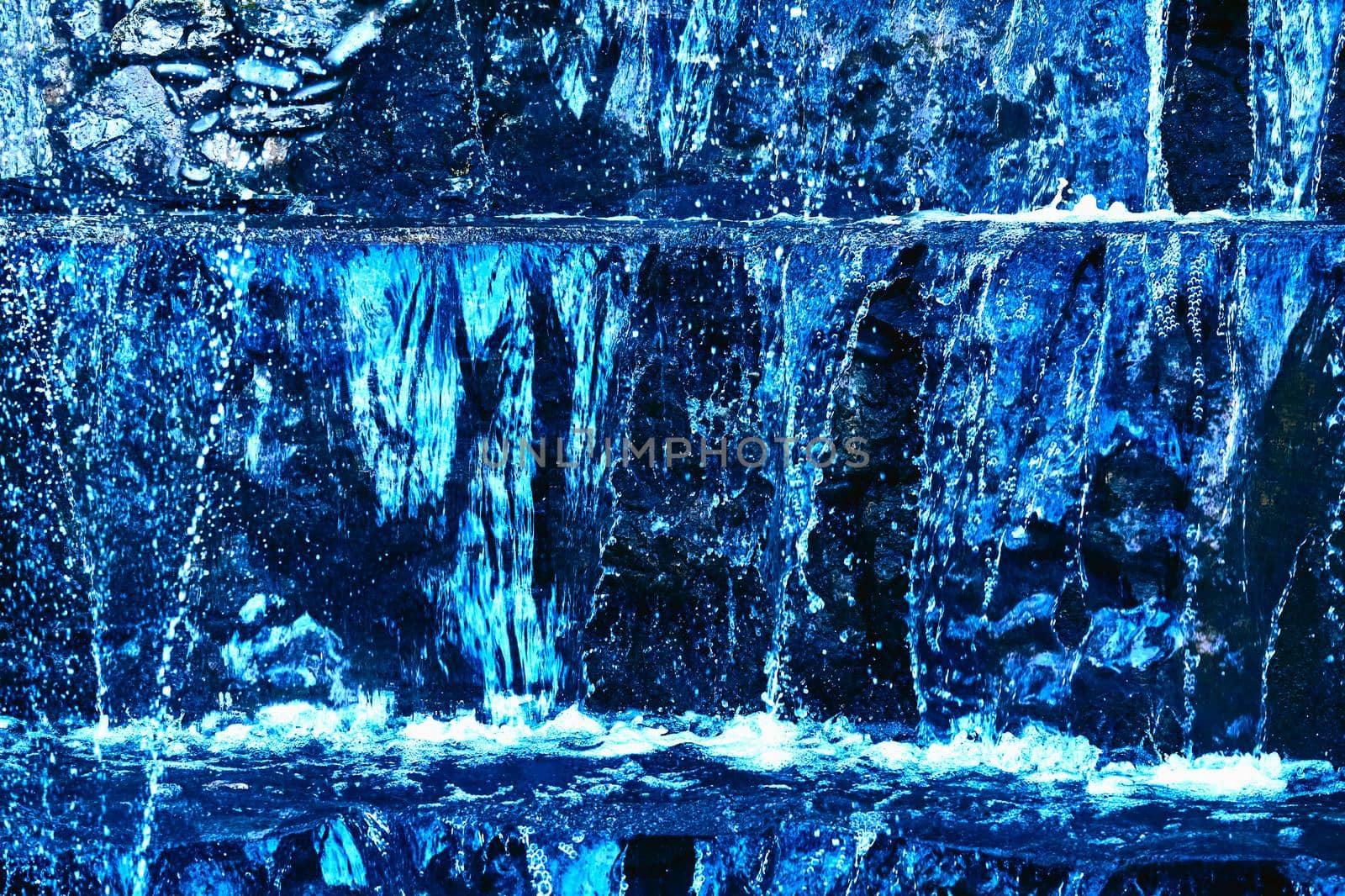 Pure mineral blue water flows over stepped mountain stones by jovani68