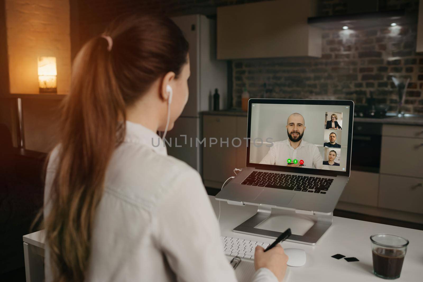 earview of businesswoman in a video conference with her boss and colleagues during an online meeting. Man in a video call with partners. Multiethnic business team having a discussion in a video call