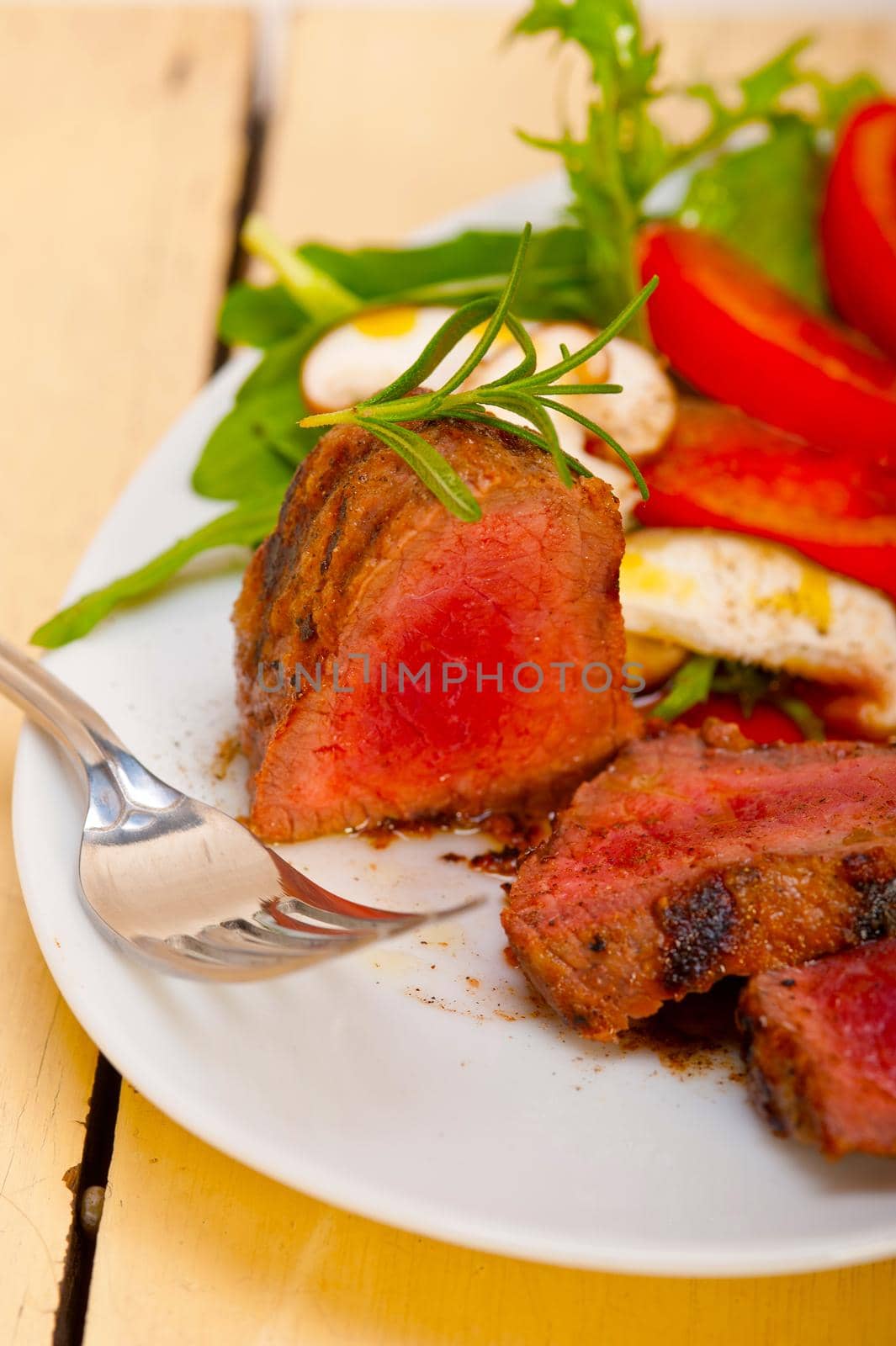 beef filet mignon grilled with fresh vegetables on side ,mushrooms tomato and arugula salad