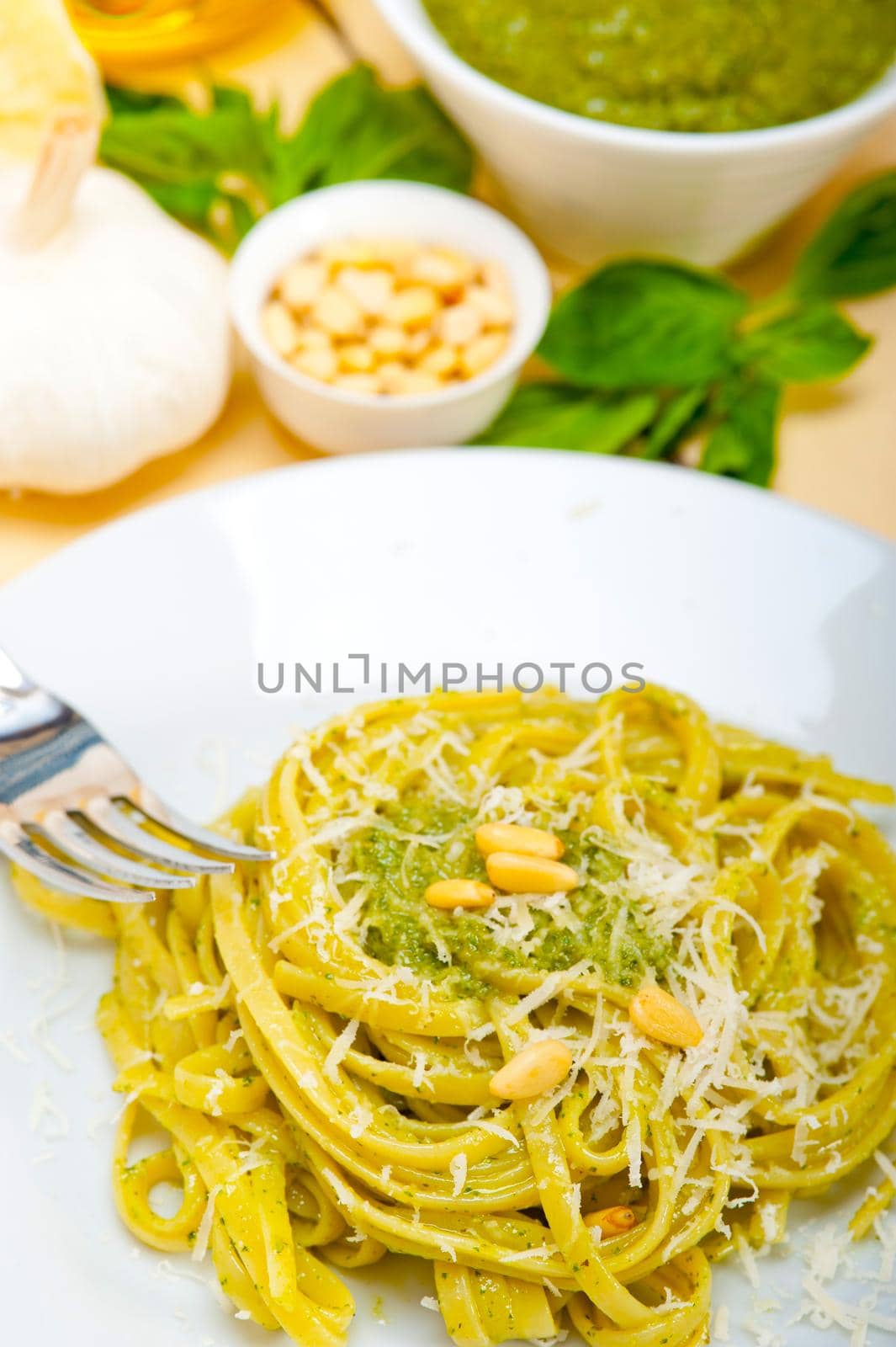 Italian traditional basil pesto pasta ingredients parmesan cheese pine nuts extra virgin olive oil garlic on a rustic table 