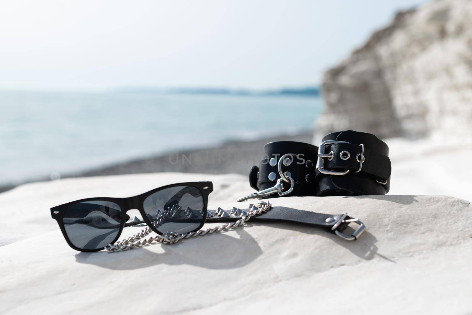 leather handcuffs for bdsm sex toys on the beach while on vacation in summer by Rotozey
