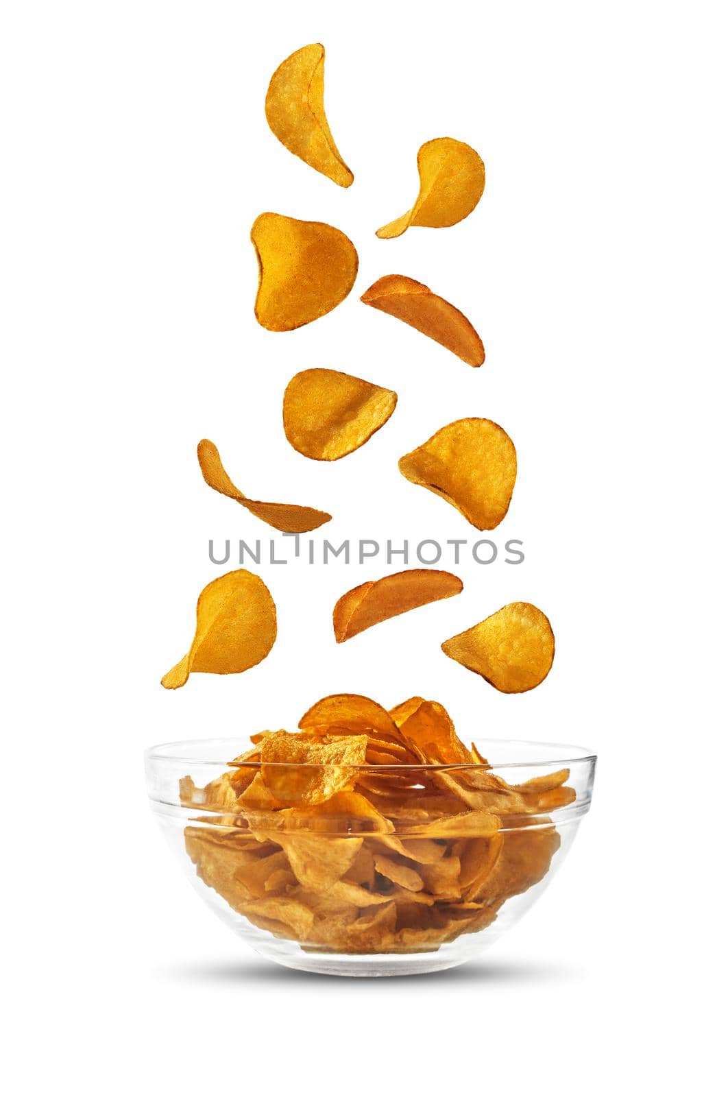 Potato crisps falling down in glass bowl, isolated on white background with copy space for text, images. Crispy chips. Advertising. Close-up. by nazarovsergey