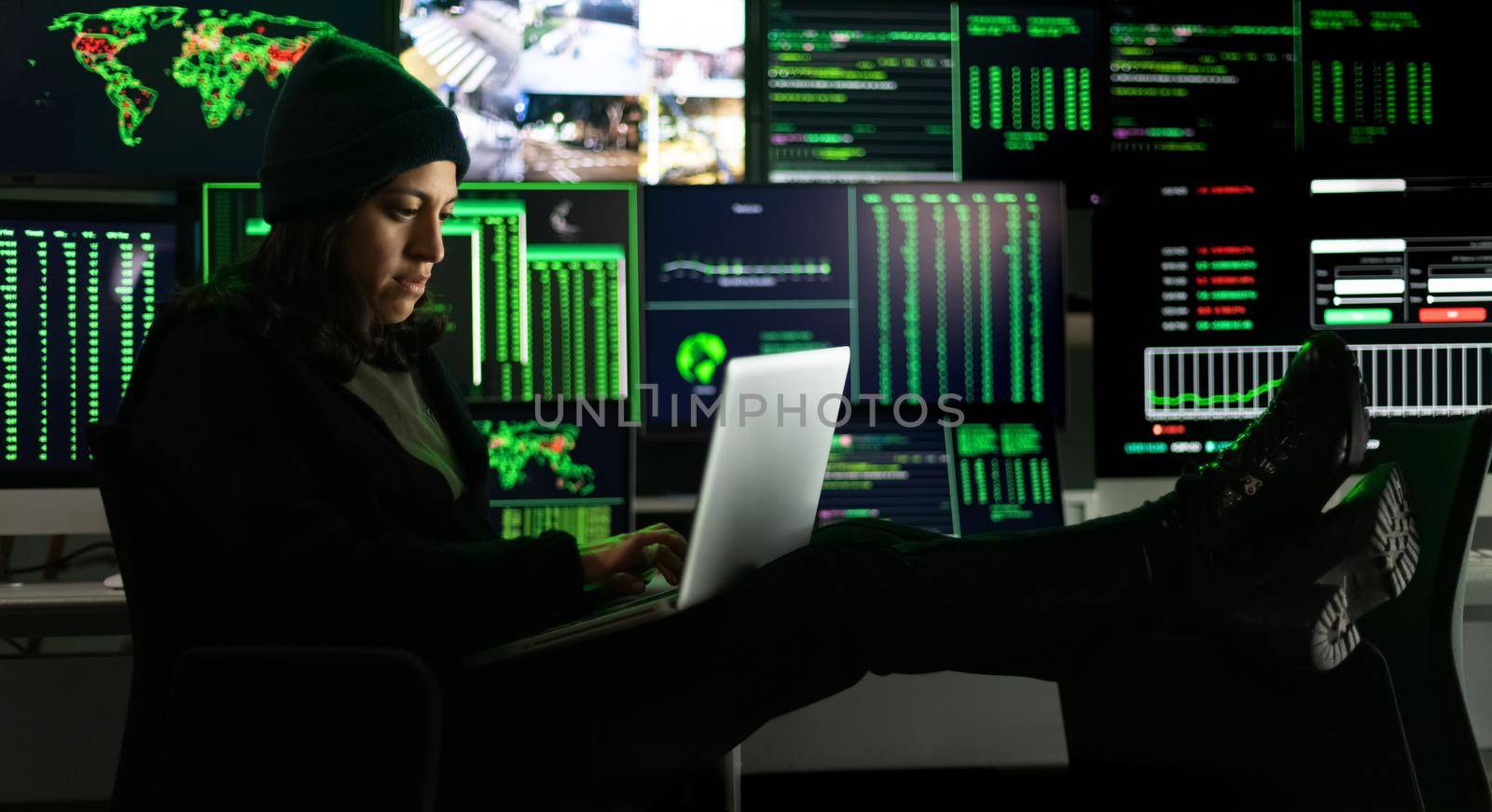 Horizontal banner image of hispanic female hacker hacking security firewall late at night in basement hideout. Multiple screen background. Dark theme.