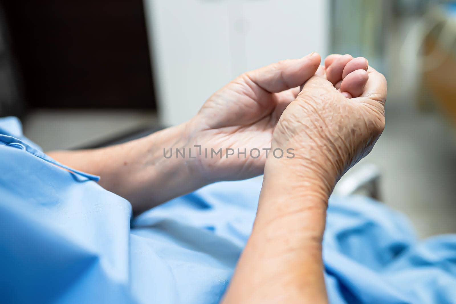 Asian senior or elderly old woman patient pain trigger finger lock her hand while sitting on bed in nursing hospital ward : healthy strong medical concept. by pamai