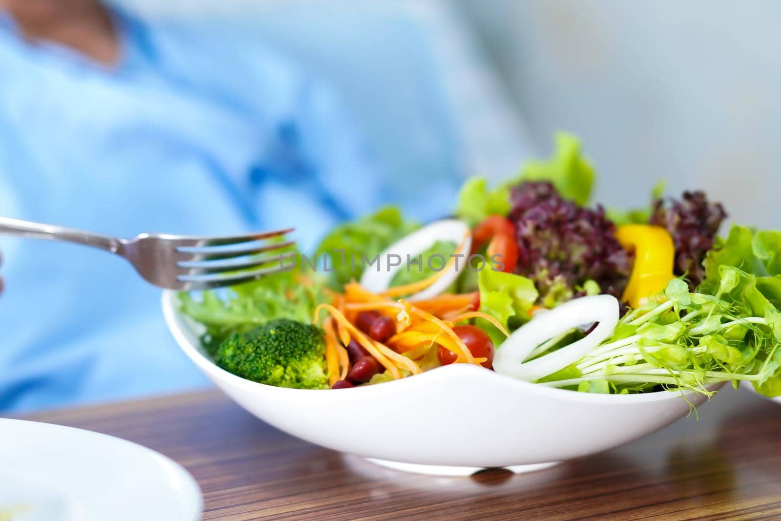 Asian senior or elderly old lady woman patient eating breakfast vegetable healthy food with hope and happy while sitting and hungry on bed in hospital.