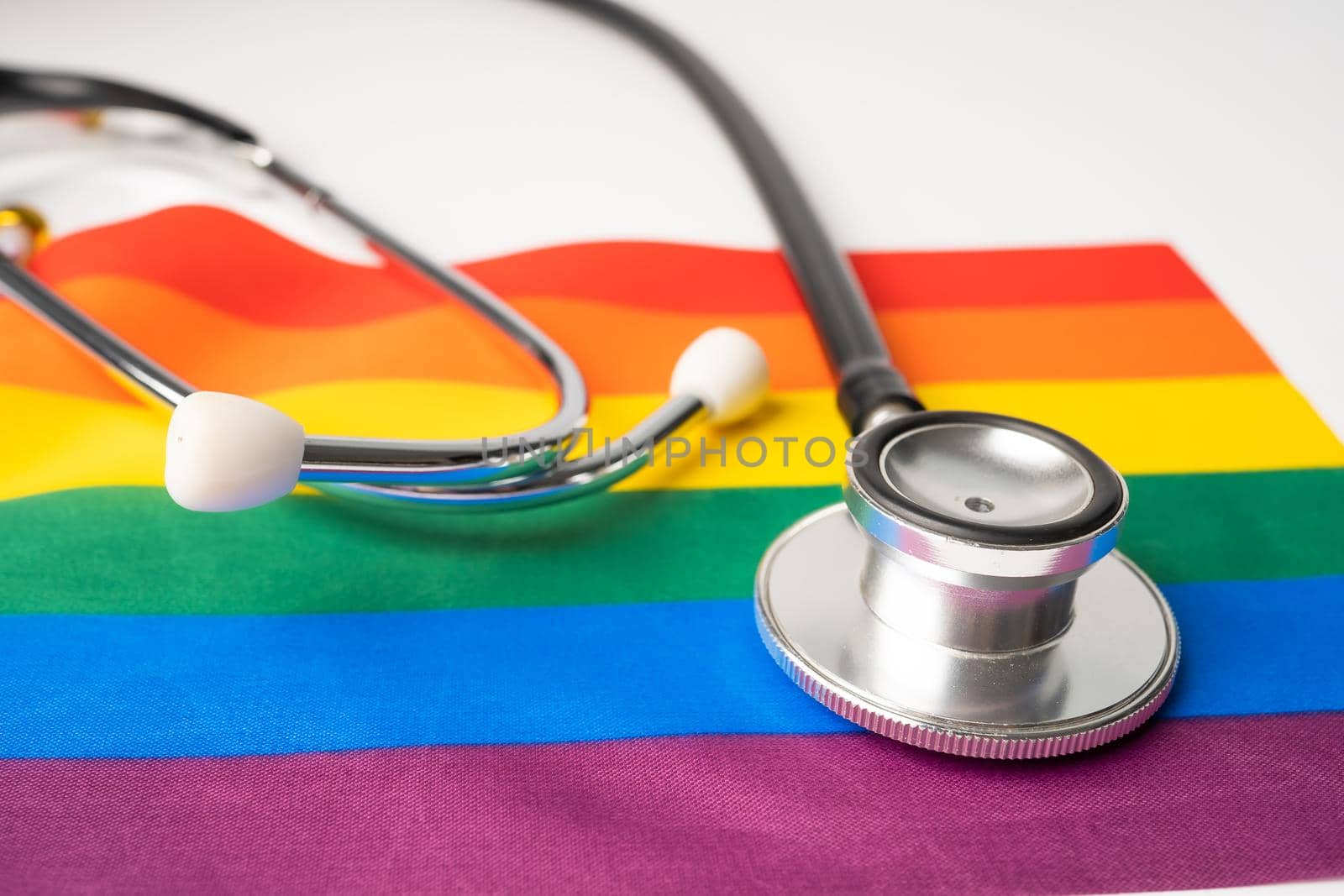 Black stethoscope on rainbow background, symbol of LGBT pride month celebrate annual in June social, symbol of gay, lesbian, gay, bisexual, transgender, human rights and peace.