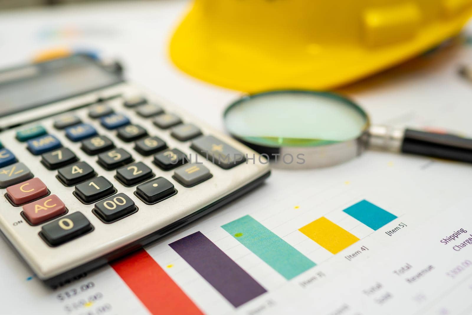 Calculator with yellow construction helmet on chart and graph paper. Finance development, Banking Account, Statistics, Investment Analytic research data economy, Stock exchange trading, Business company concept.