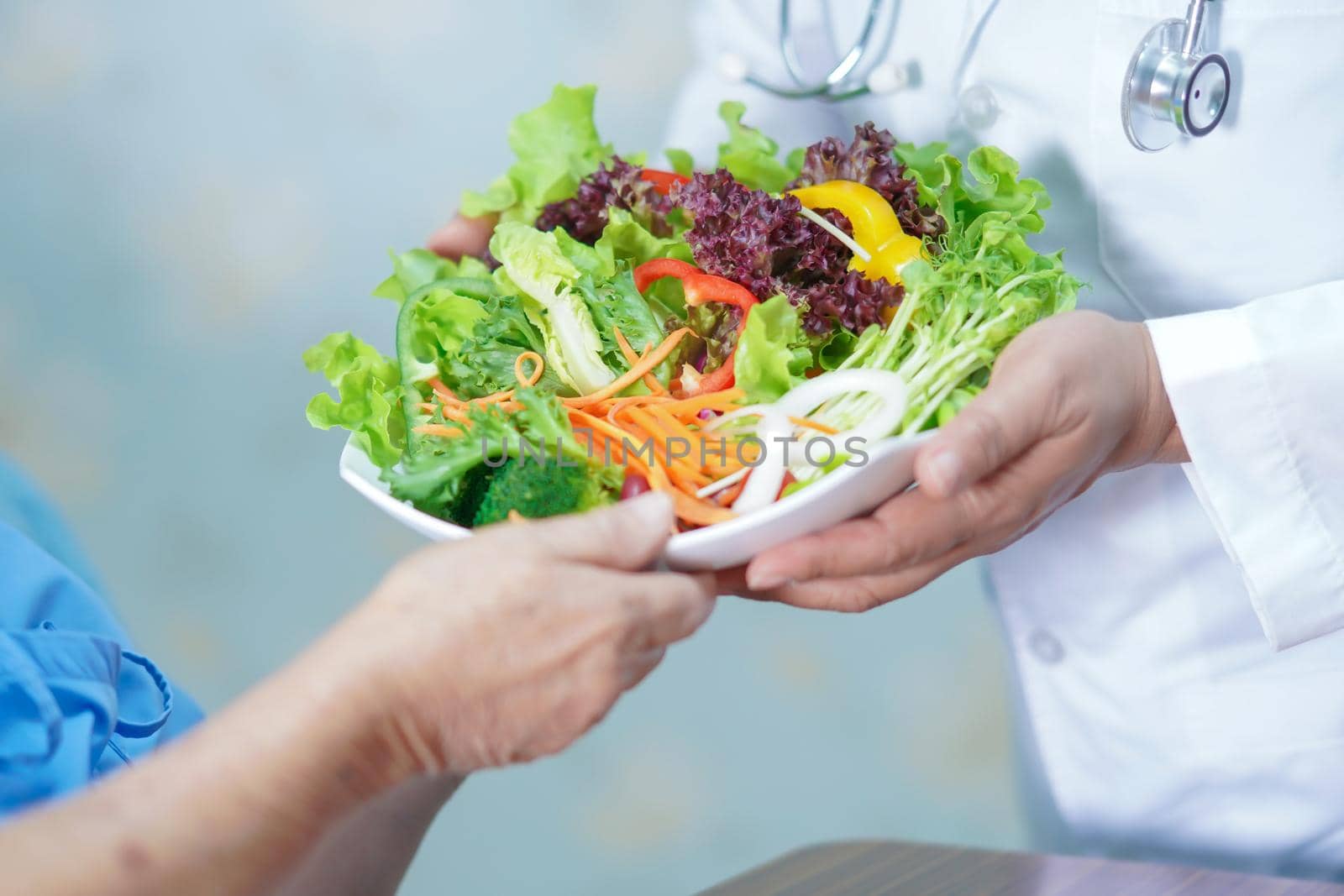 Asian senior or elderly old lady woman patient eating breakfast vegetable healthy food with hope and happy while sitting and hungry on bed in hospital.