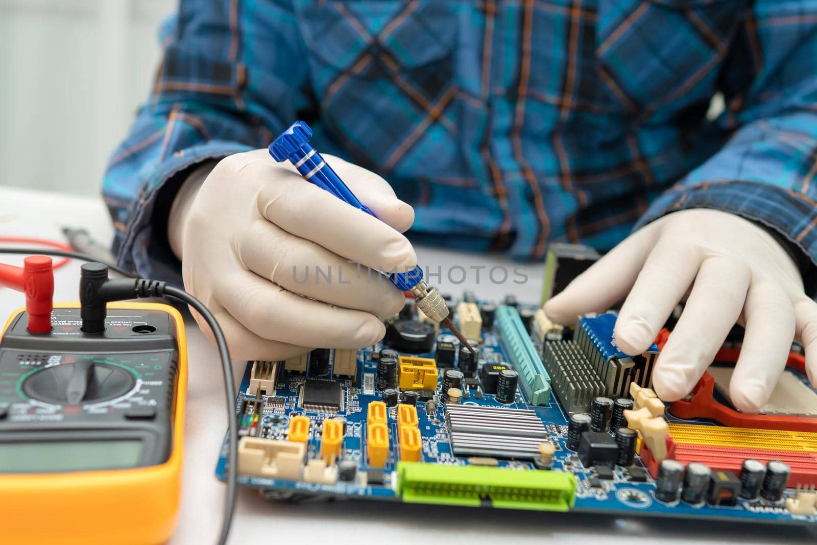 technician repairing inside of hard disk by soldering iron. Integrated Circuit. the concept of data, hardware, technician and technology. by pamai