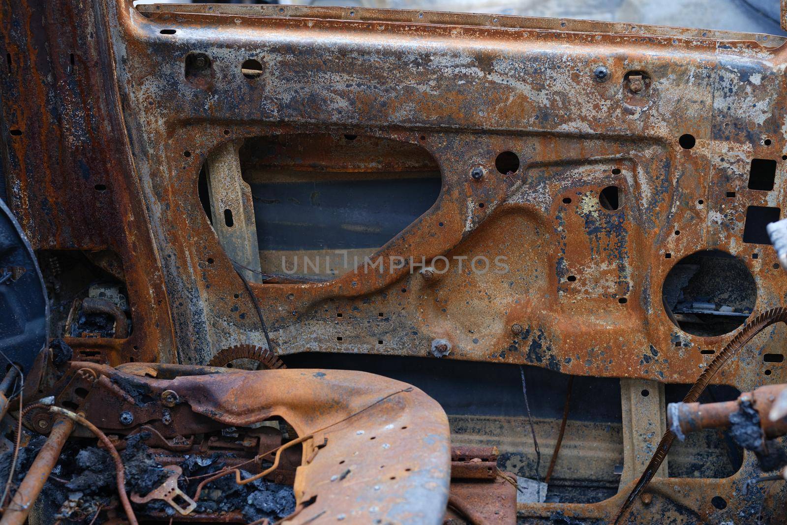 Burnt car after accident. Transport insurance. Old abandoned rusty car concept