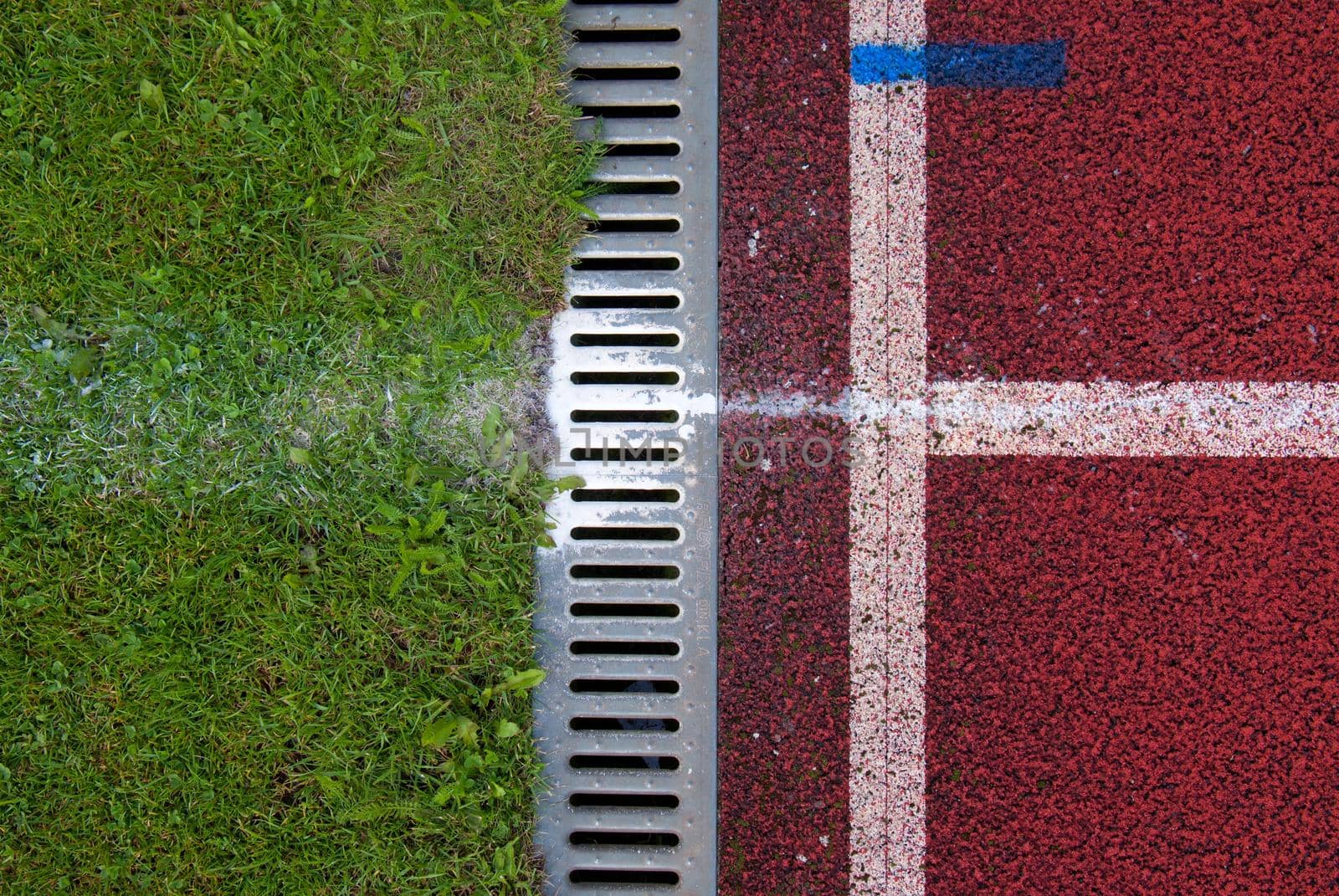 Channel at red running racetrack on the athletic stadium. Drain by rdonar2