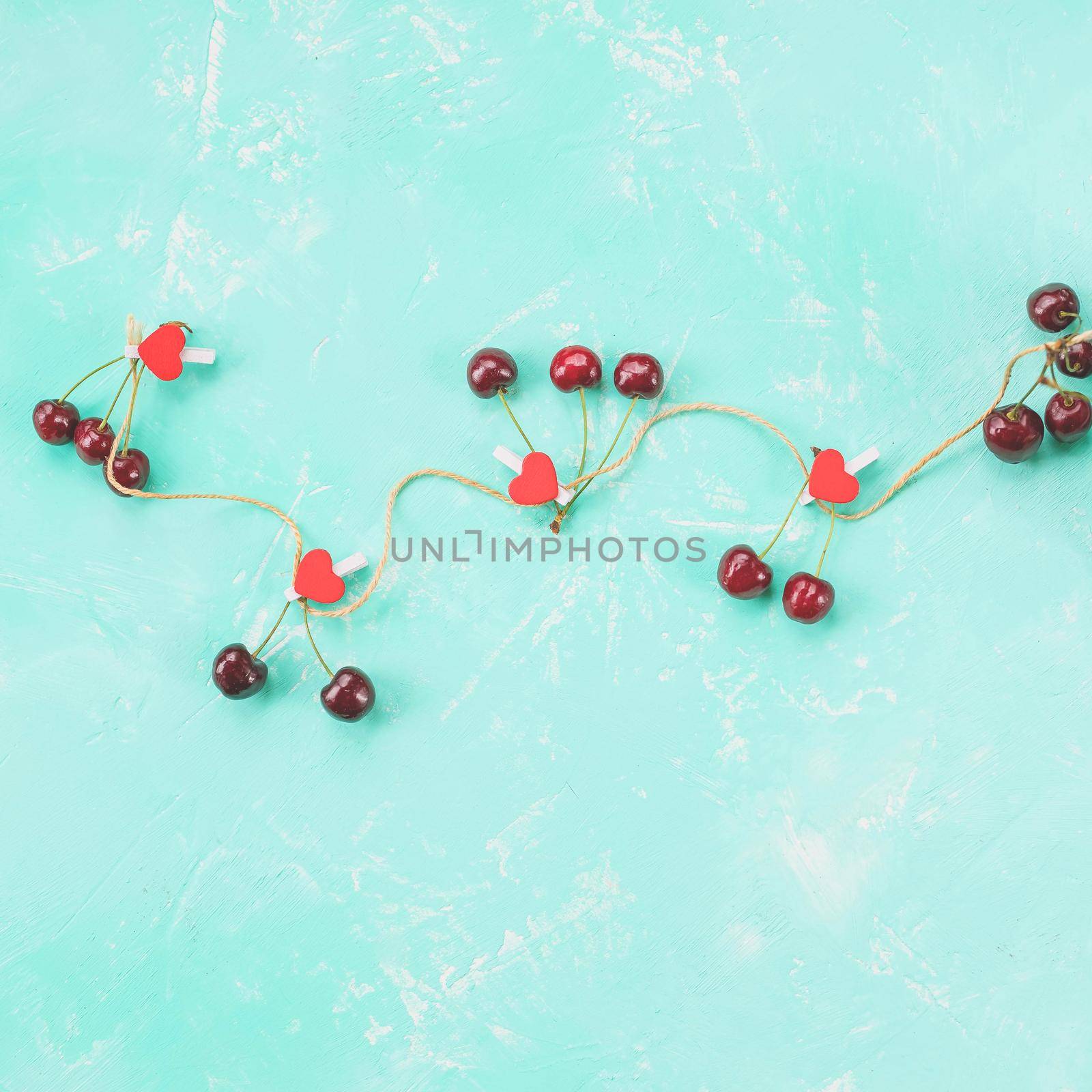 Ripe red sweet cherries arranged in the shape of a big heart on grungy table. Romantic love concept.