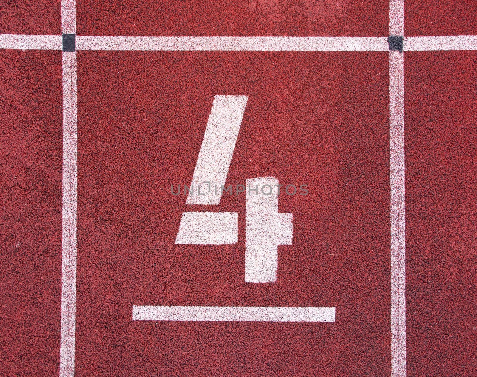 Number four. White track number on red rubber racetrack, texture of running racetracks in stadium