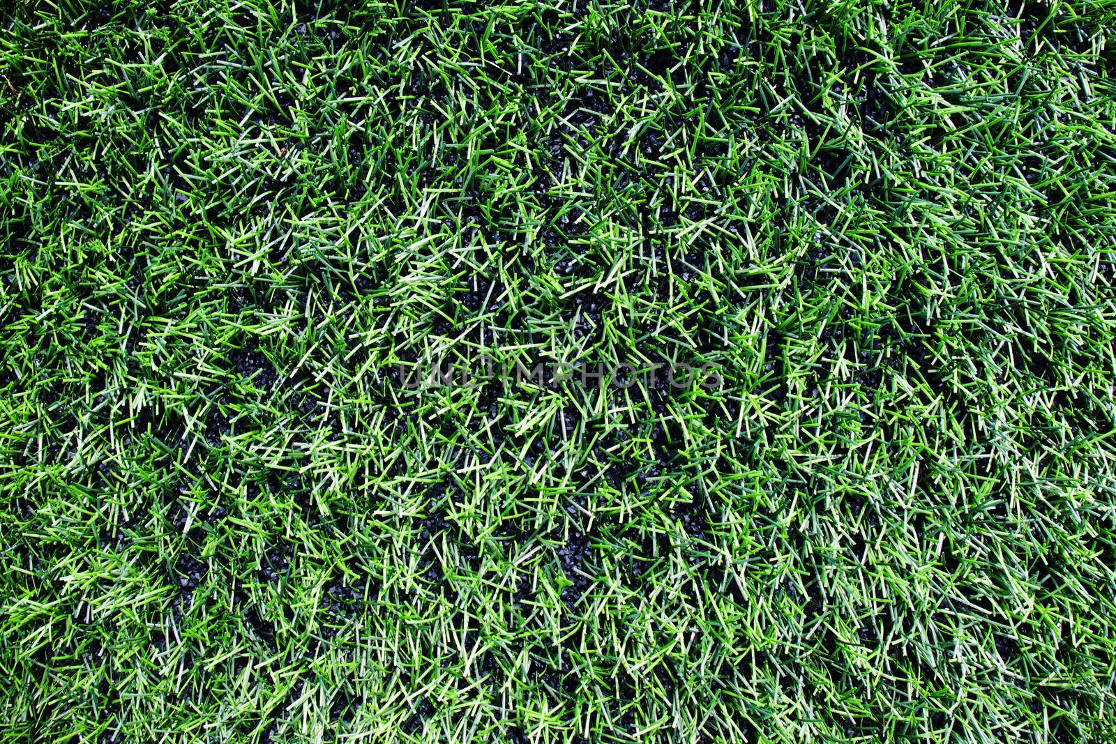 View into plastic grass, artificial green turf texture background